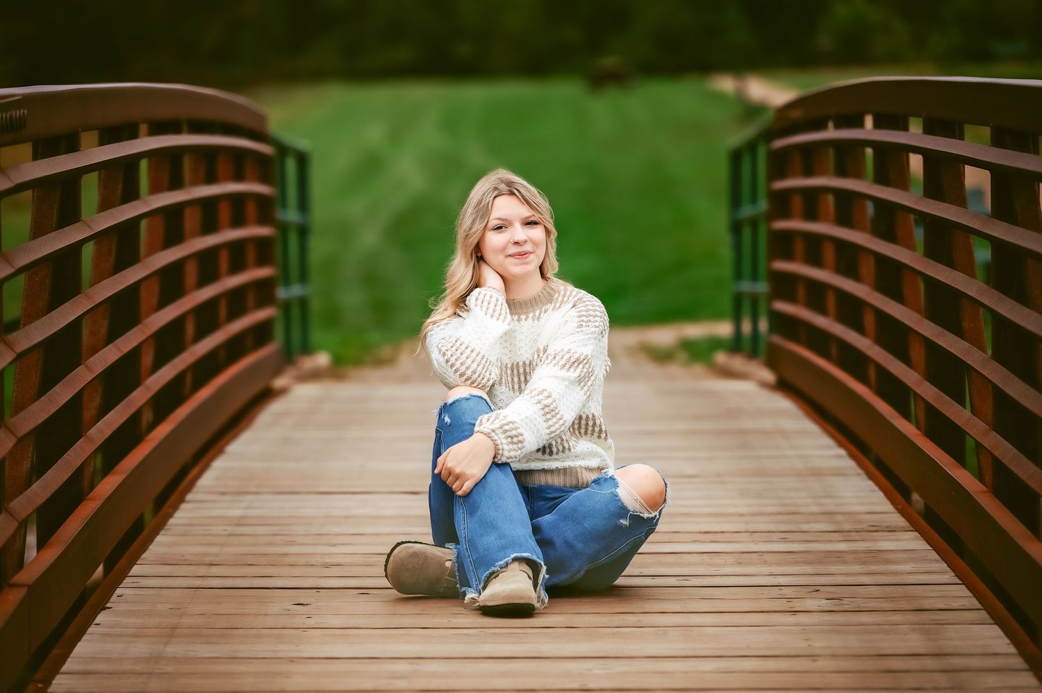 A wooden bridge provides a rustic backdrop for an outdoor portrait session.