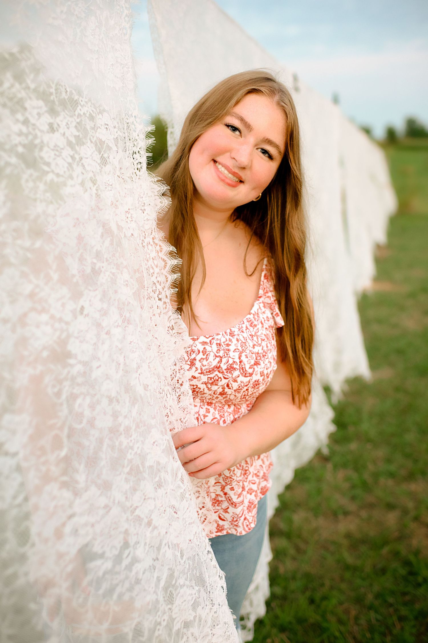 Playful portrait poses with delicate lace fabric in an outdoor setting.