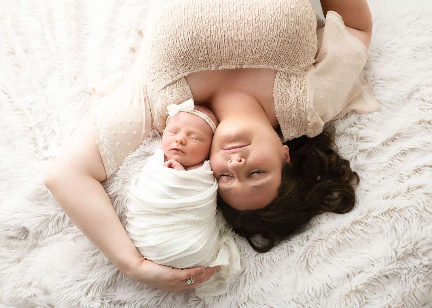 Artistic newborn photography series showing baby lying on soft white blankets in various poses.