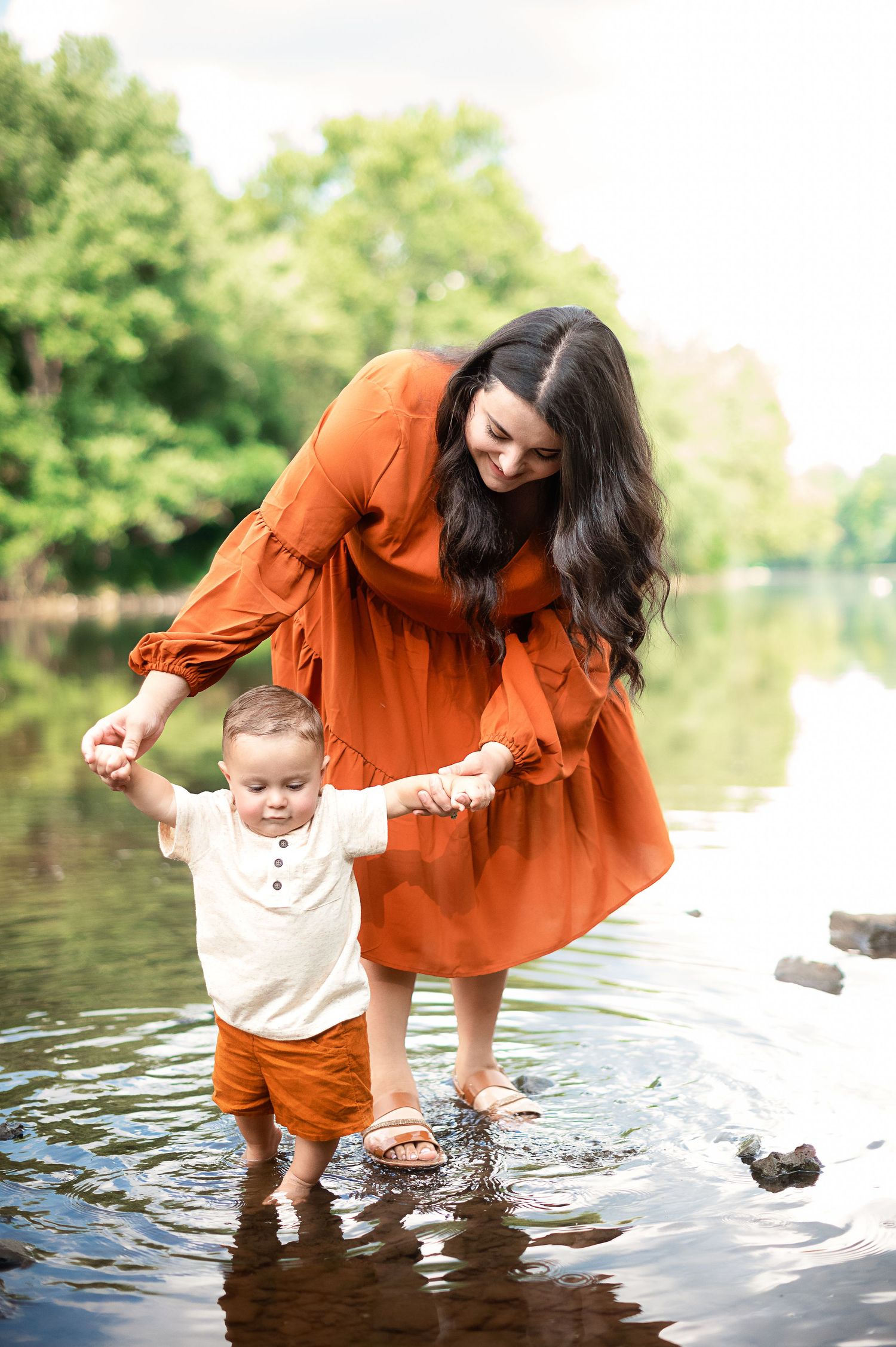 Playful moment at the water's edge with matching orange outfits.