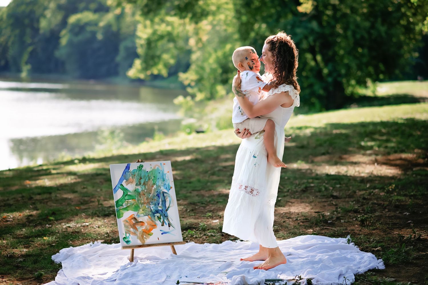 Family enjoying a picnic and painting session outdoors in a park setting.