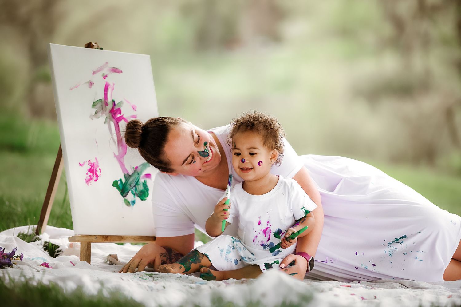 Playful outdoor maternity photoshoot with floral painting props.