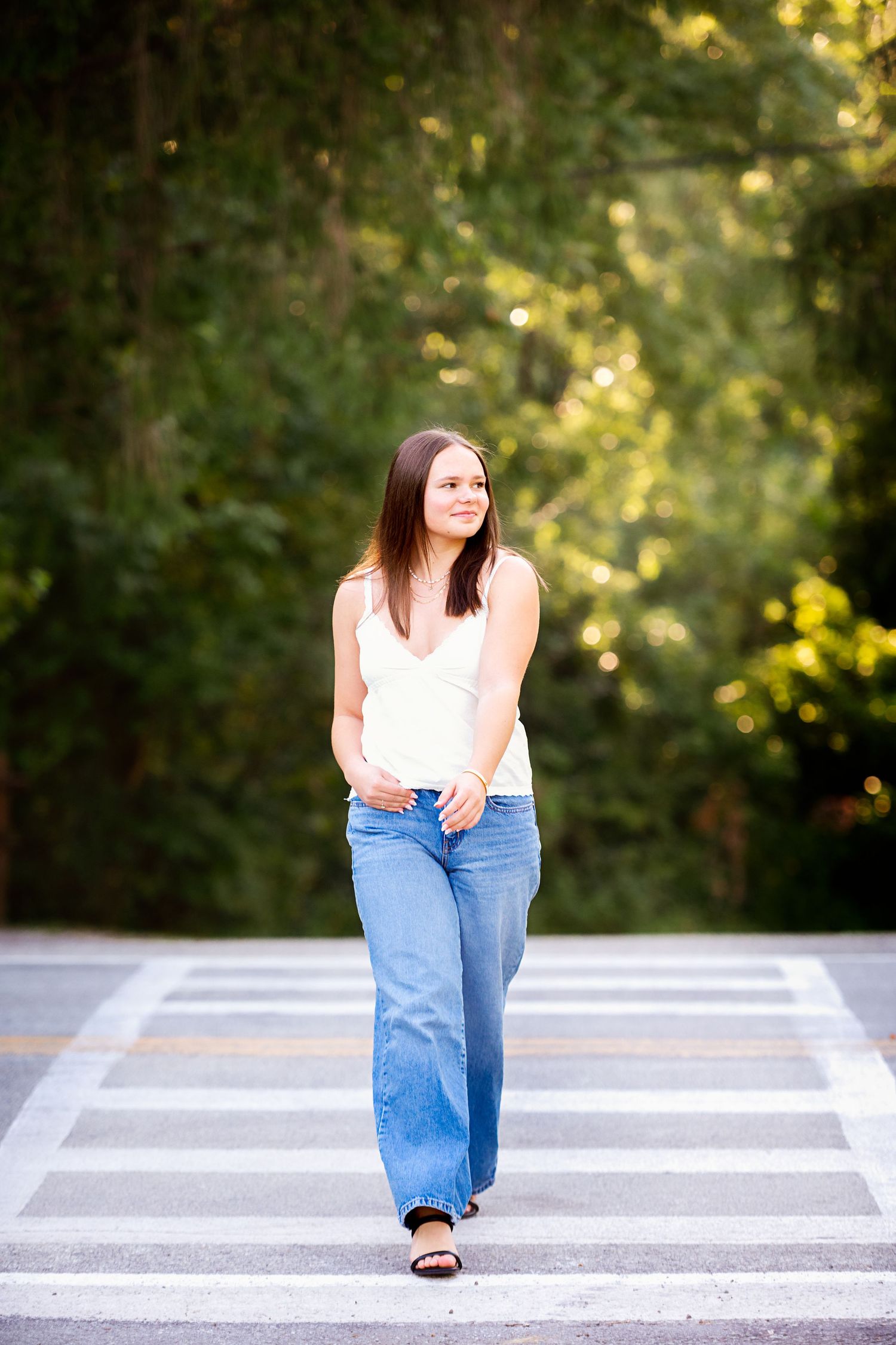 Casual portrait sequence on striped crosswalk wearing light top and classic blue jeans.