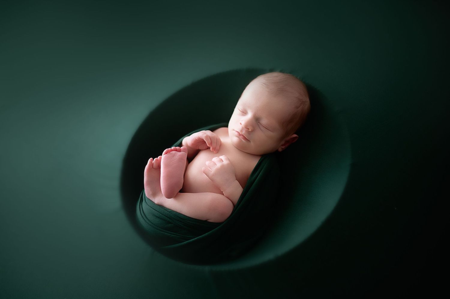 Artistic black and white newborn photography with dramatic lighting and shadows.