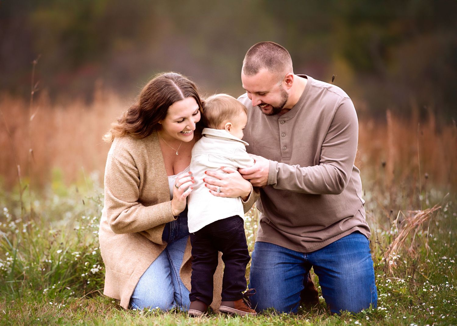 Tender family moments captured in a rustic field setting during fall.