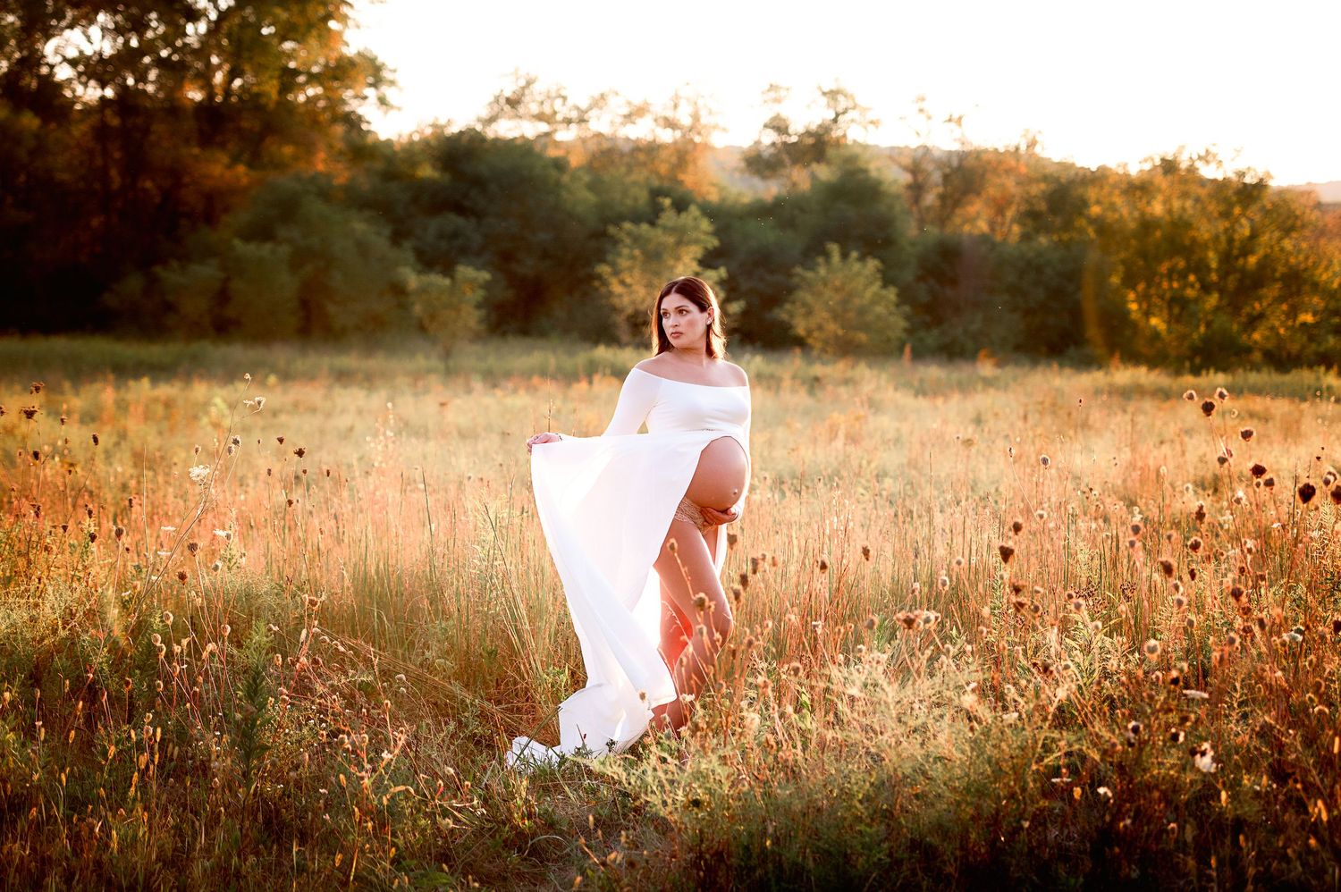 Artistic outdoor portrait session in autumn field during golden hour.