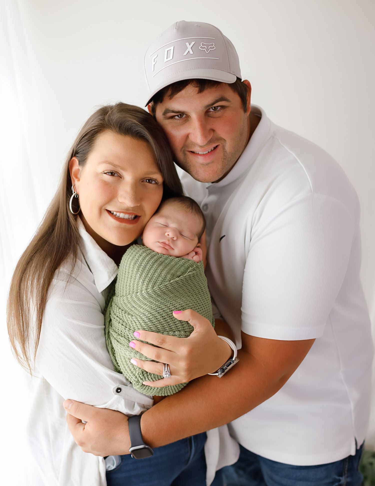 Series of casual family portraits with newborn baby in white and green tones.