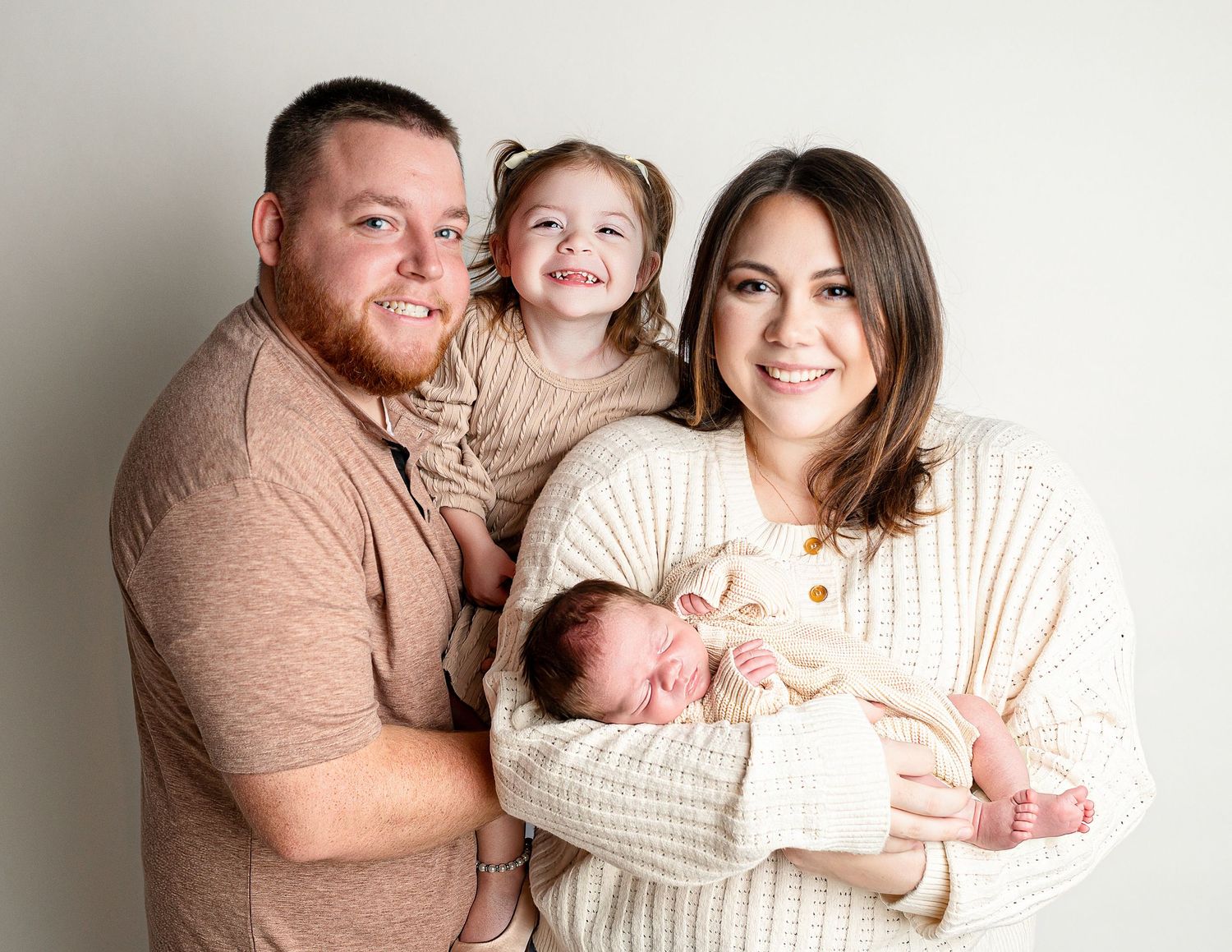 Candid family moments captured in soft neutral tones against white studio background.