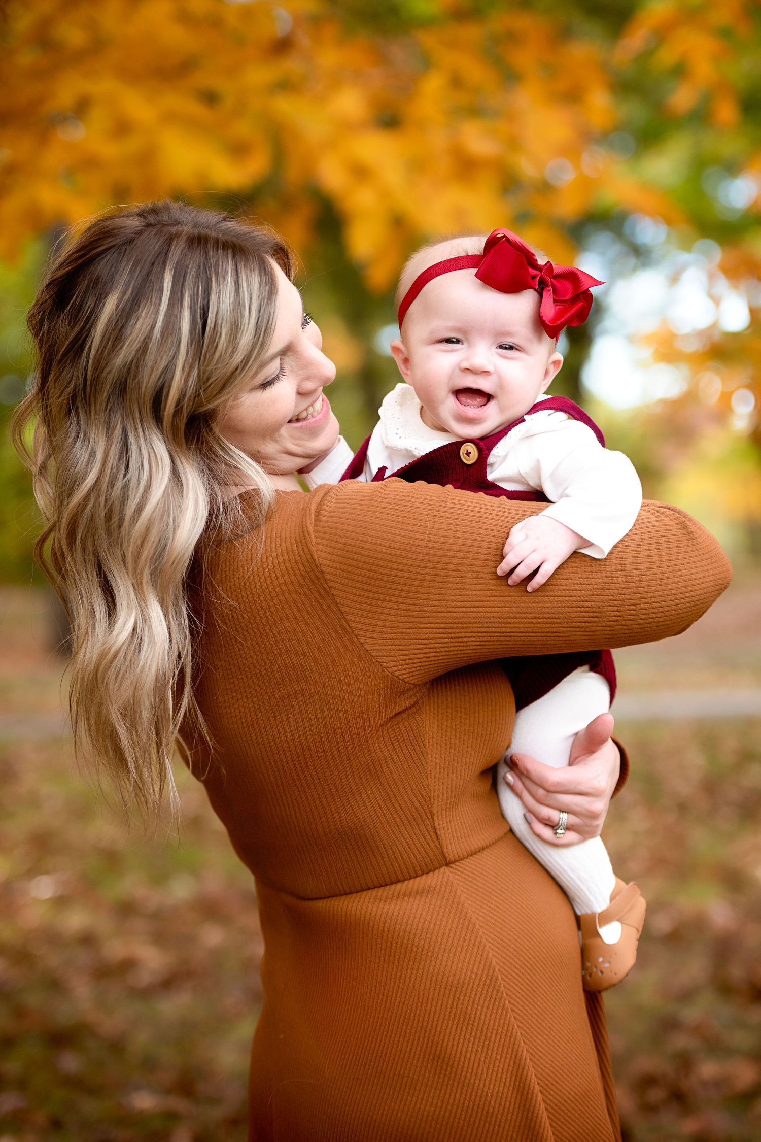 Joyful autumn portrait showing affection and laughter in warm brown tones.