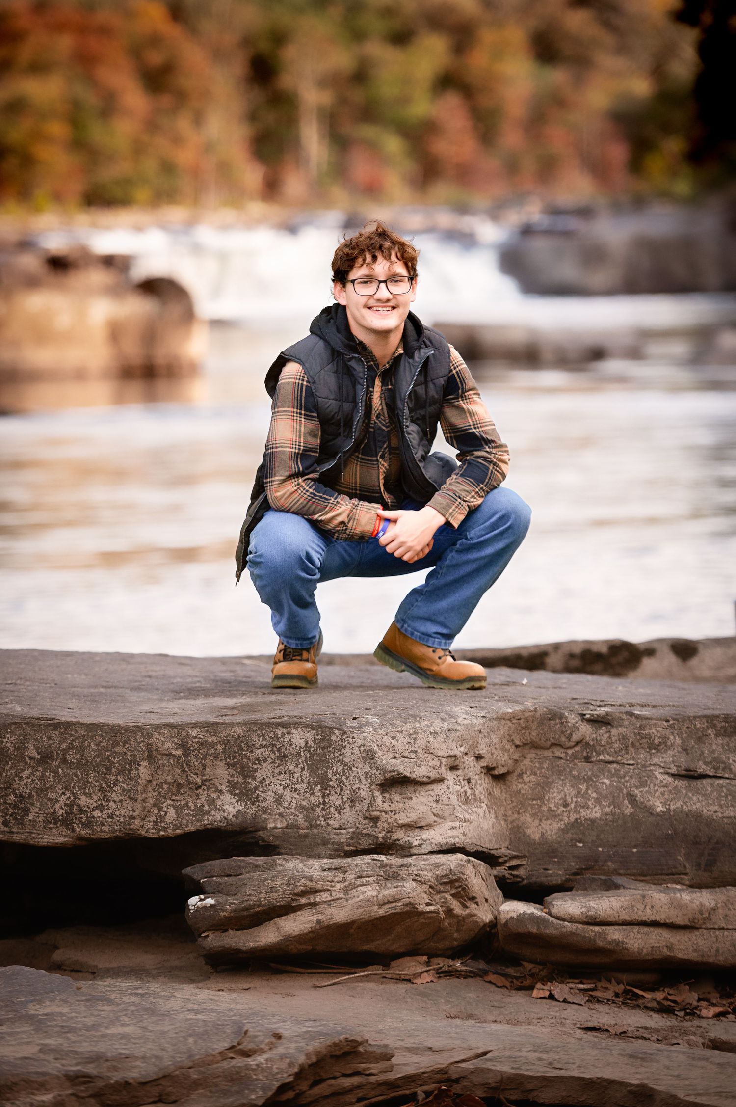 Natural poses on rocky terrain by a flowing river in autumn.