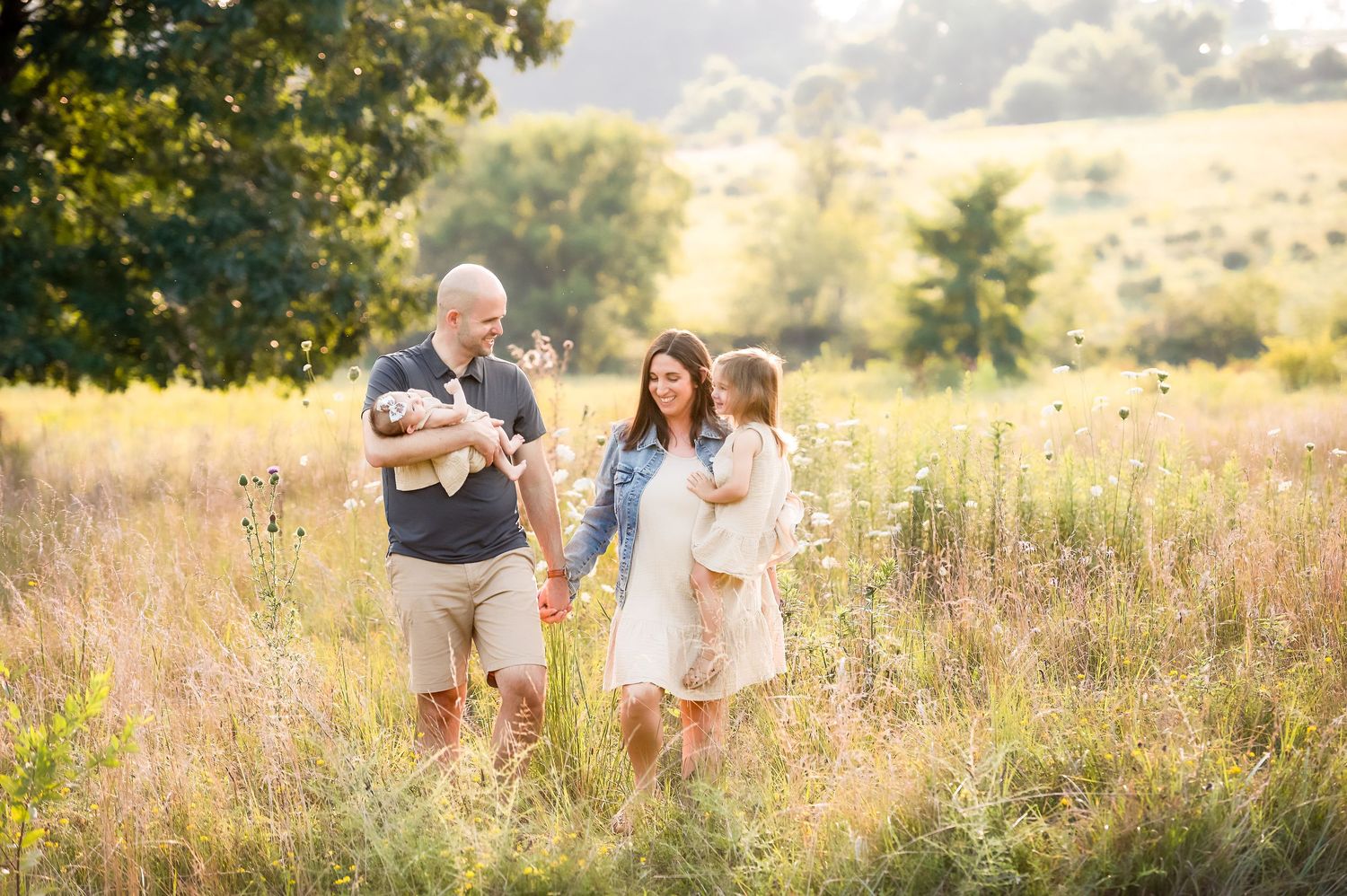 Candid family moments captured in sun-drenched summer field.