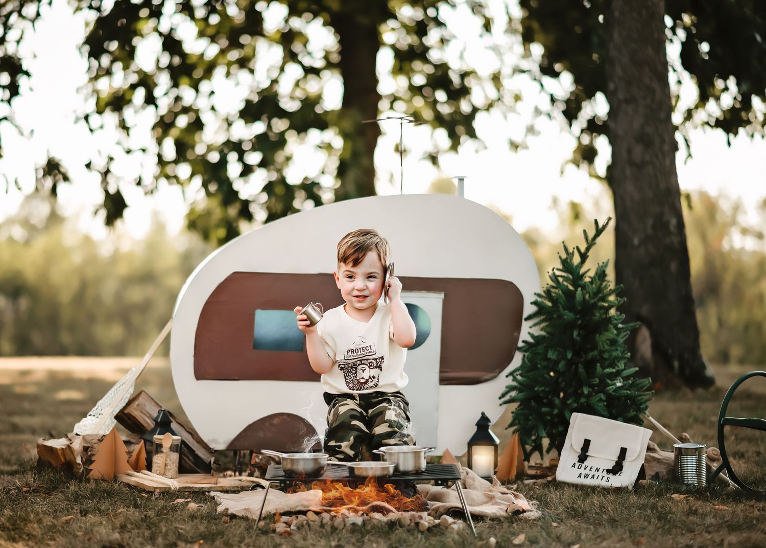 Outdoor camping scene with white trailer and trees in natural setting.