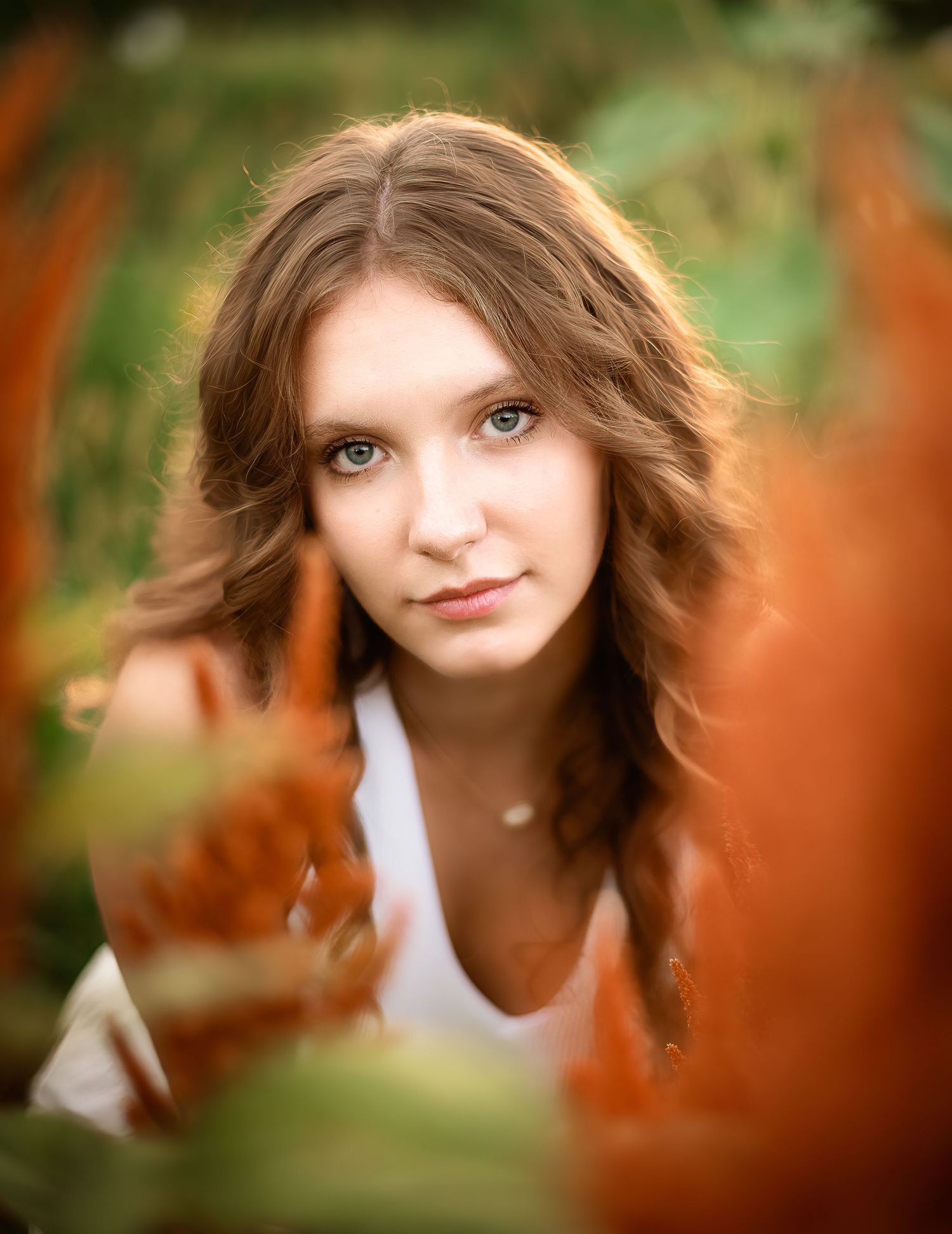 Portrait series with creative framing and soft autumn colors through leaves and foliage.