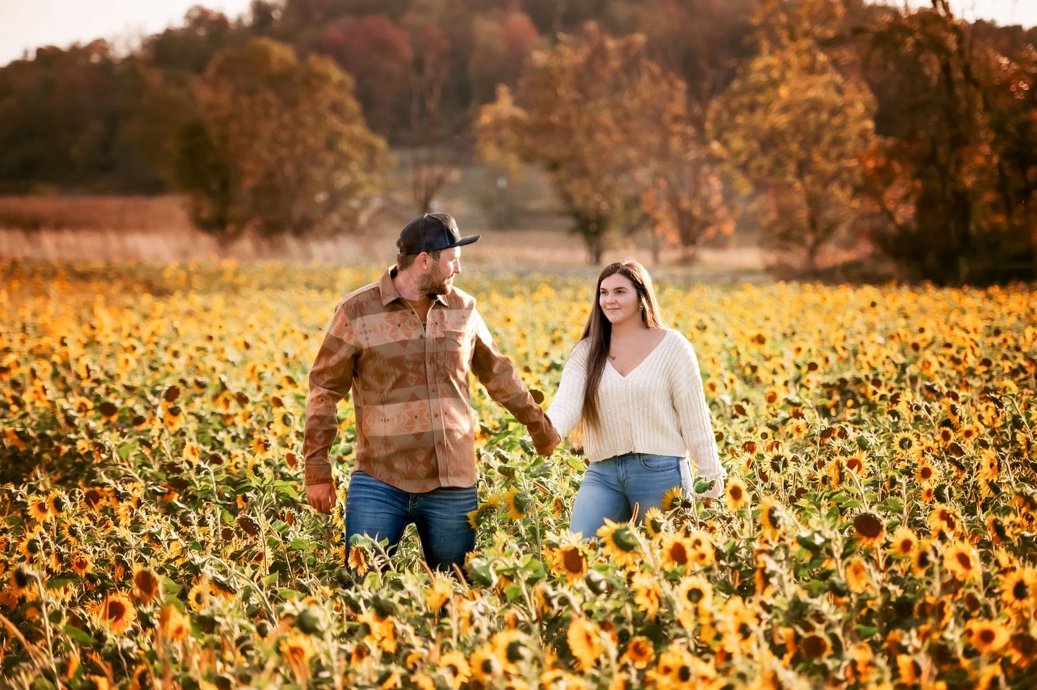 Scenic autumn landscape with sunflower field during golden hour.