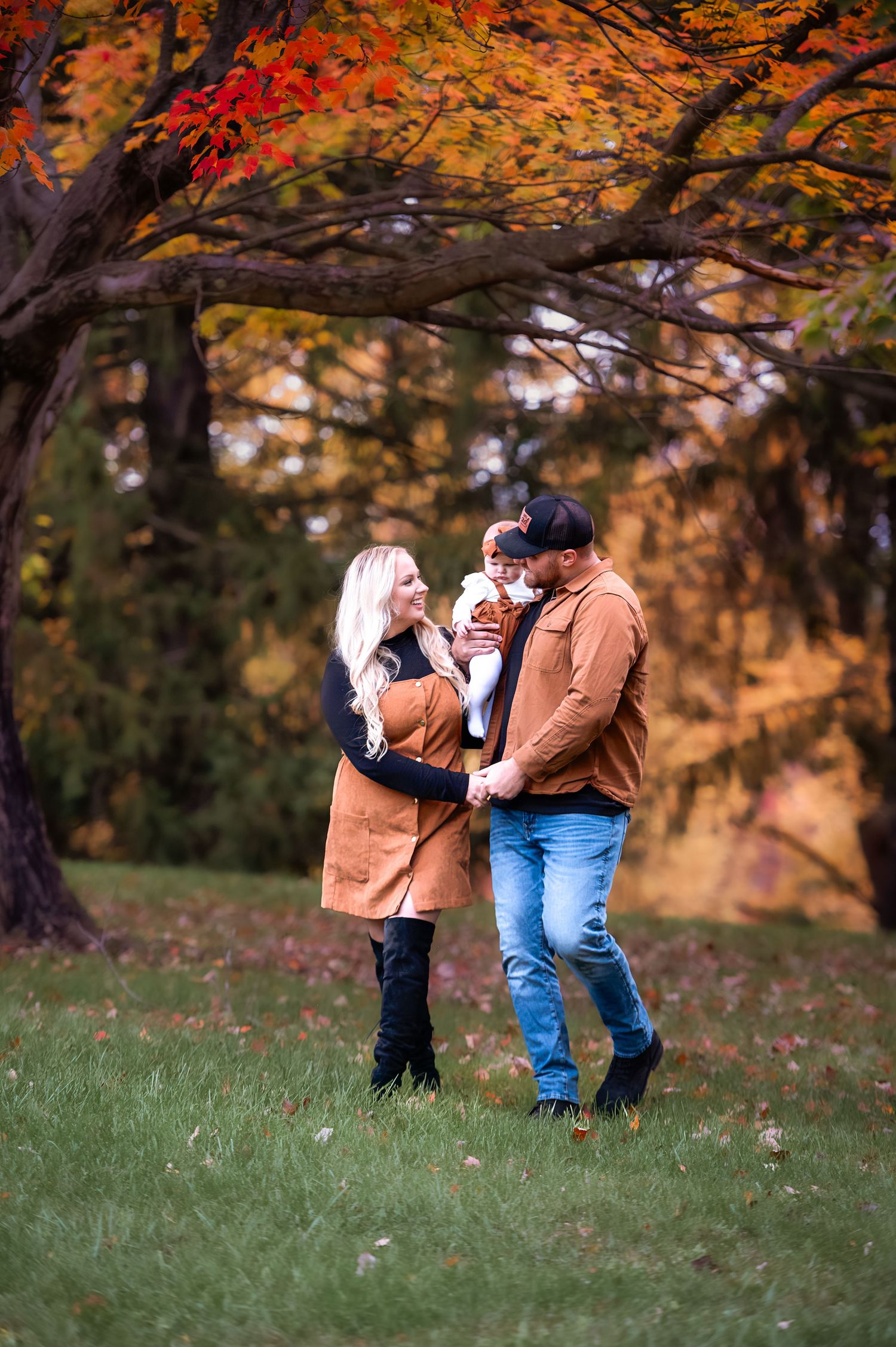 Beautiful fall photography session under vibrant orange and red maple trees.