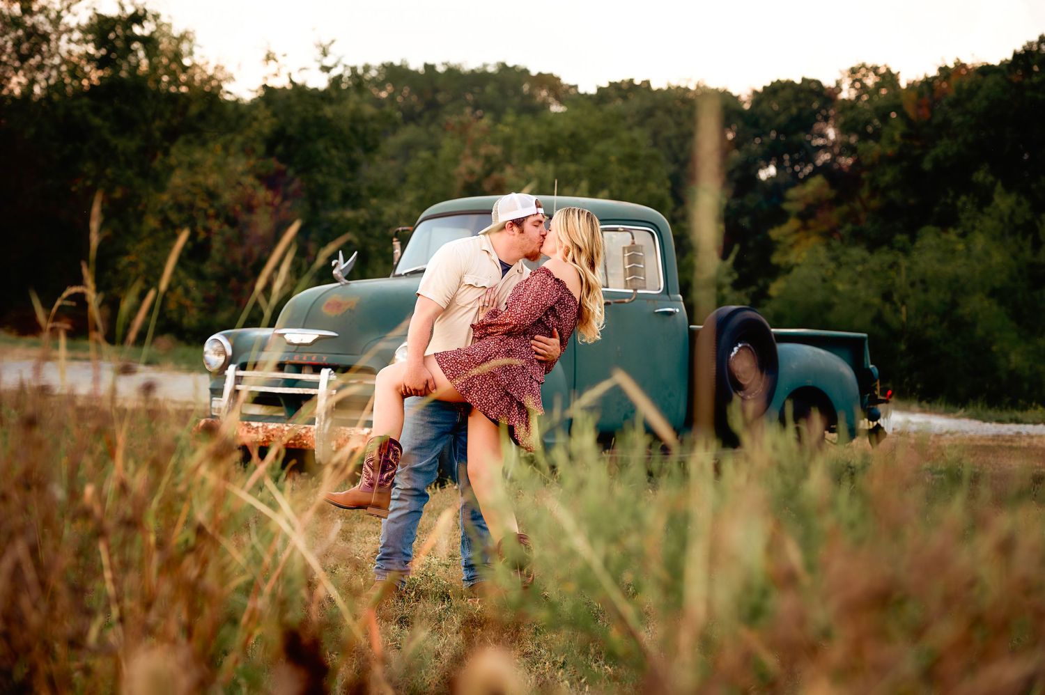 A casual outdoor photoshoot in a rustic field setting during sunset.