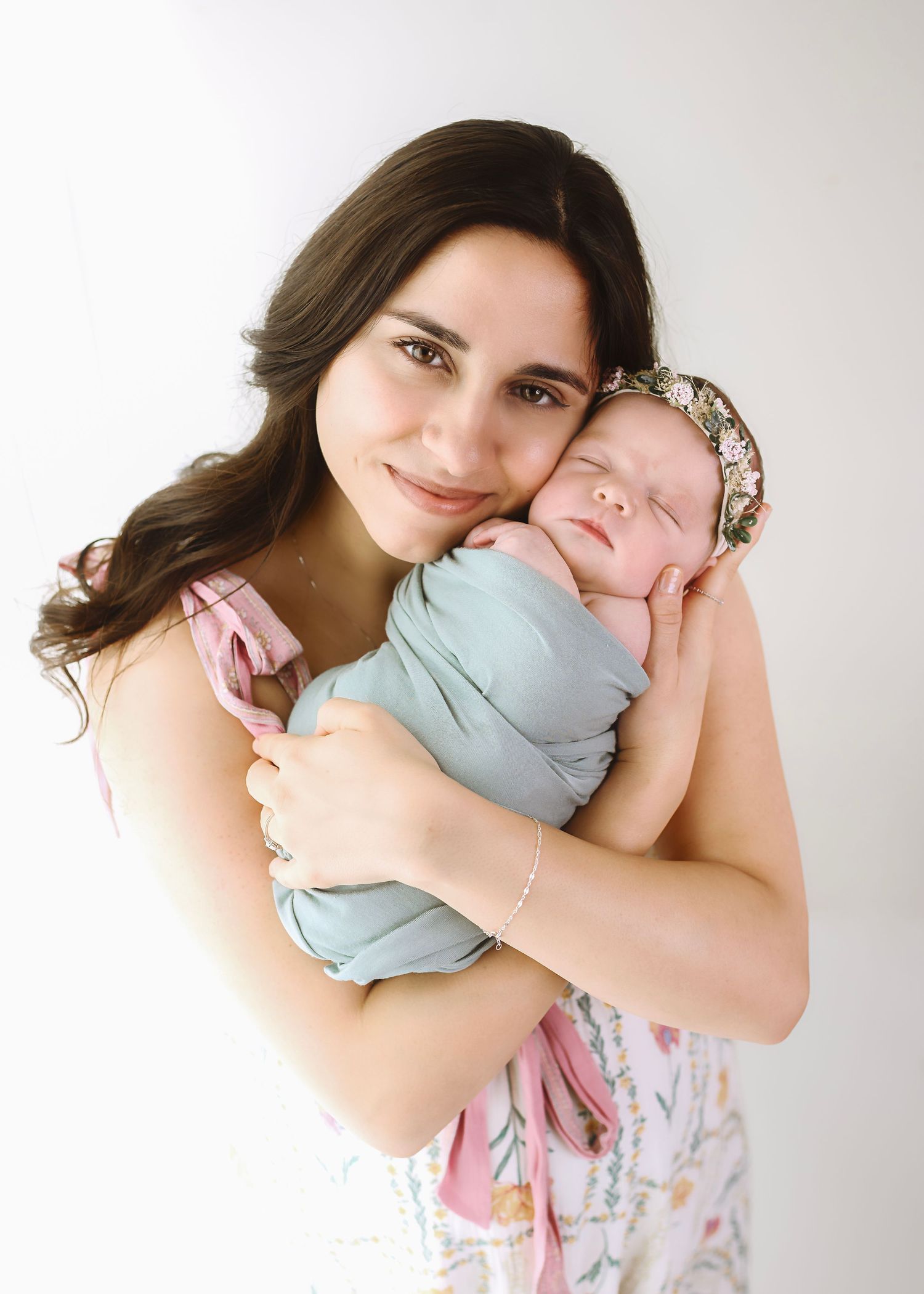 Mother and baby sharing tender moments against a white studio backdrop.