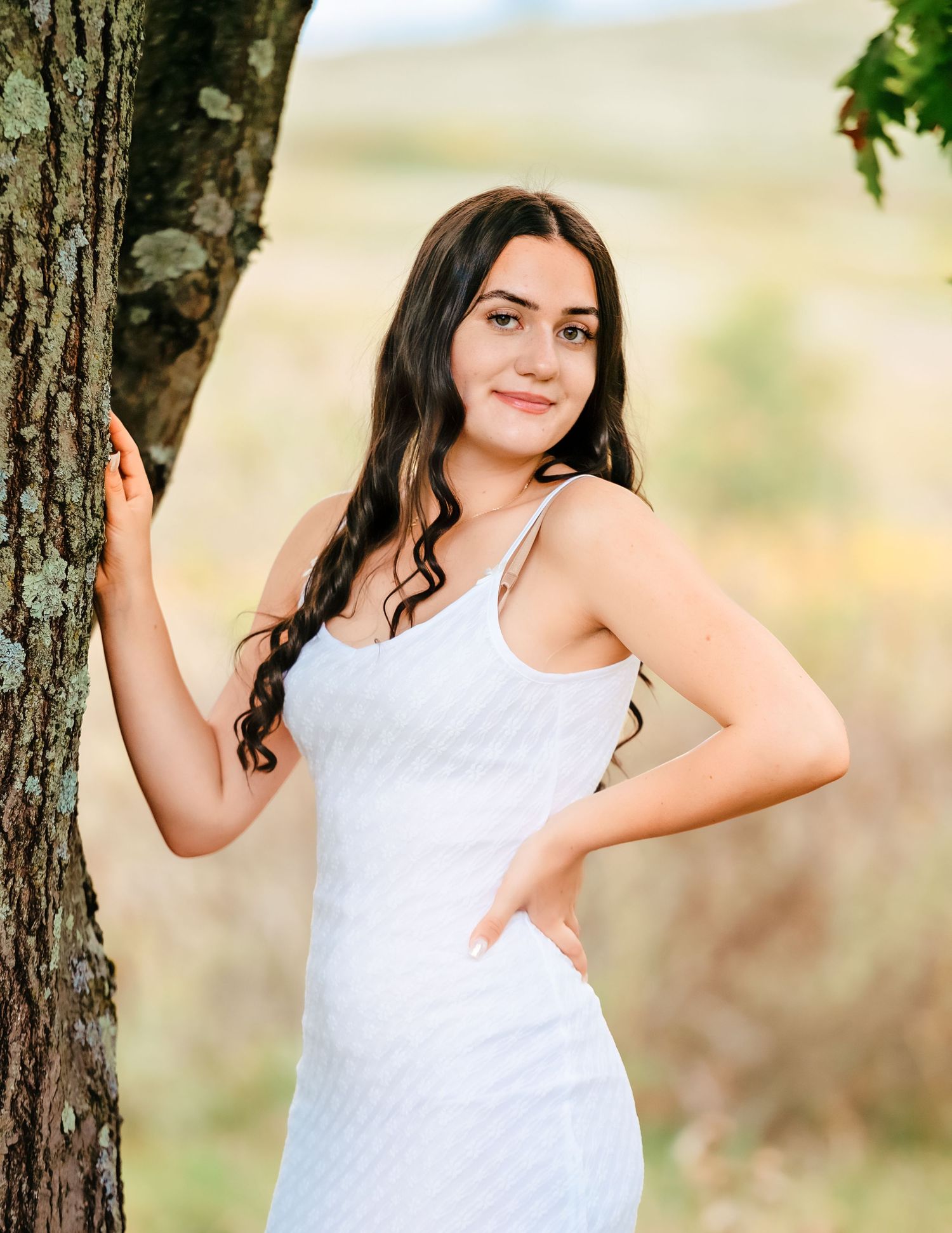 Summer portraits taken near a large tree trunk with soft natural lighting.