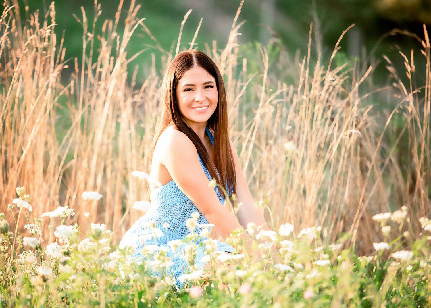 Artistic portrait series captured in a field with wildflowers and tall grass at golden hour.