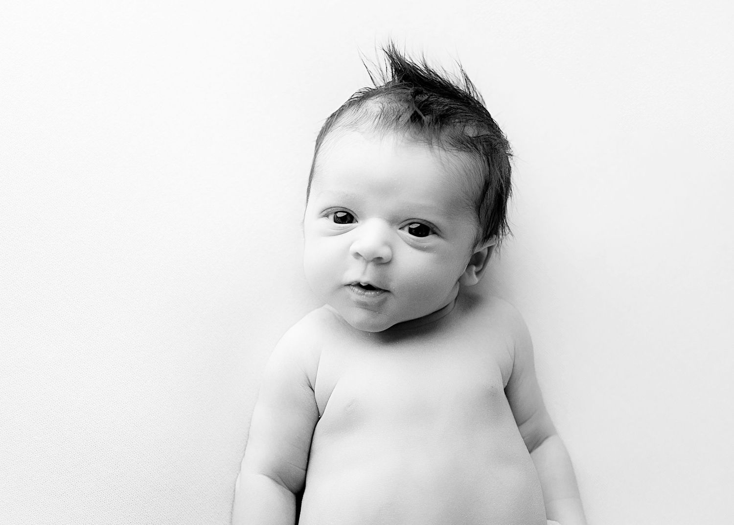Black and white portrait series of newborn baby with natural expressions.