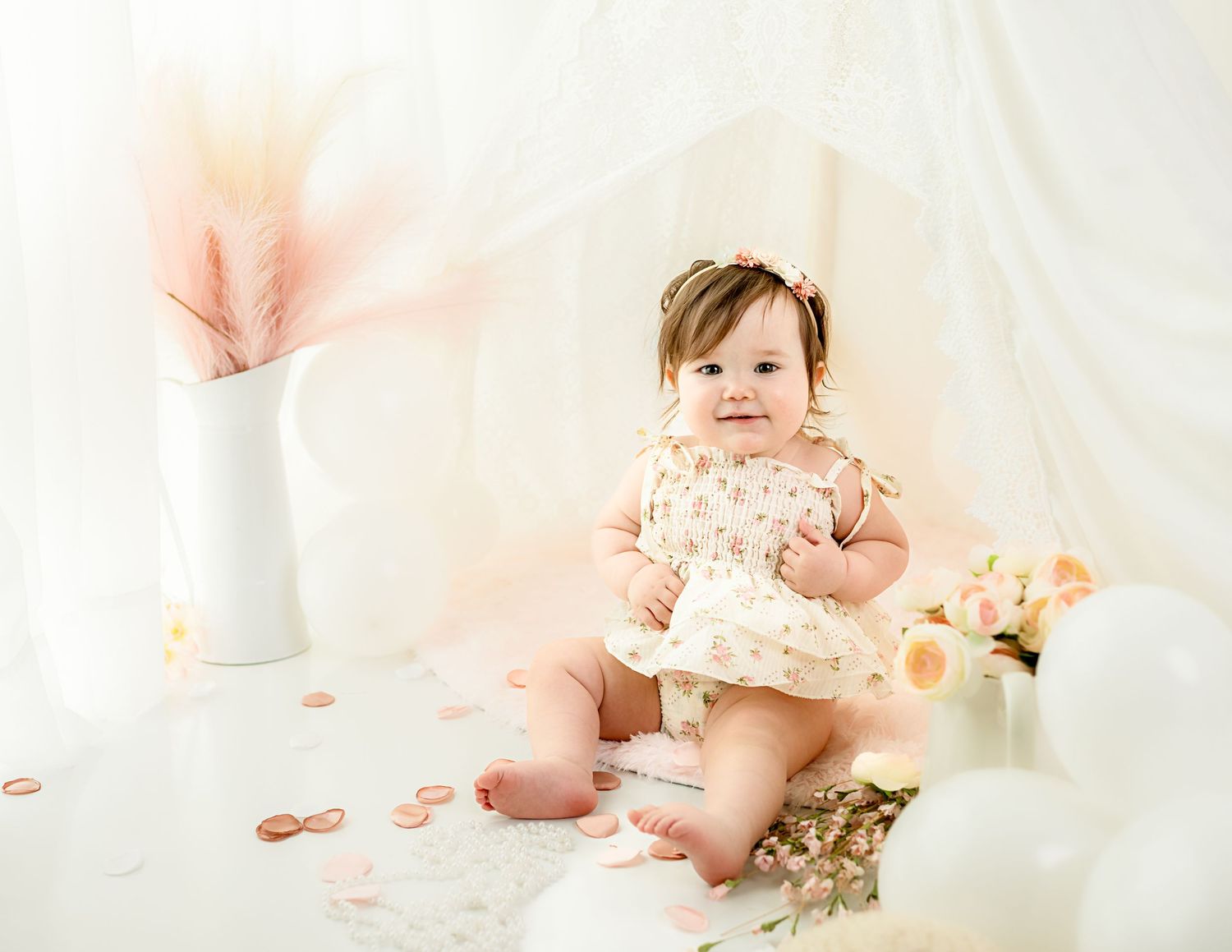 Soft pastel photography setup with white fabric backdrop and delicate lighting.