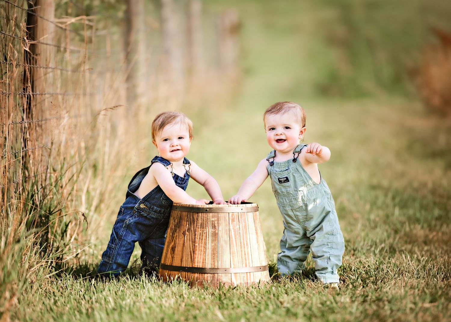 Children sit near wooden barrels in a rustic outdoor setting.