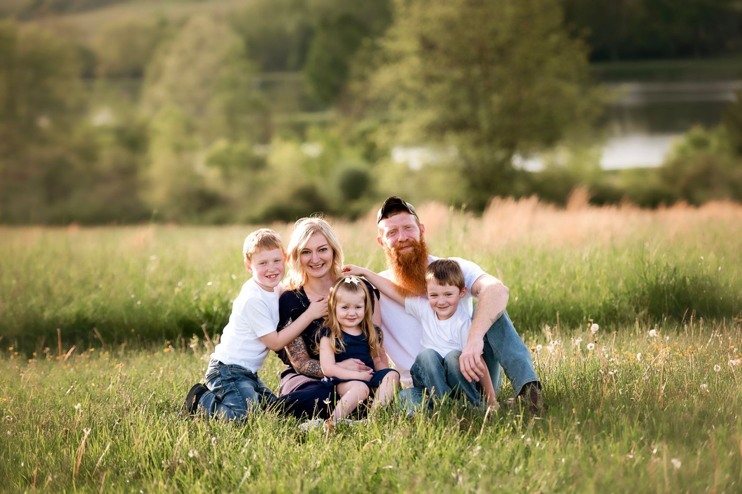 Candid family moment captured in natural outdoor setting with green landscape.
