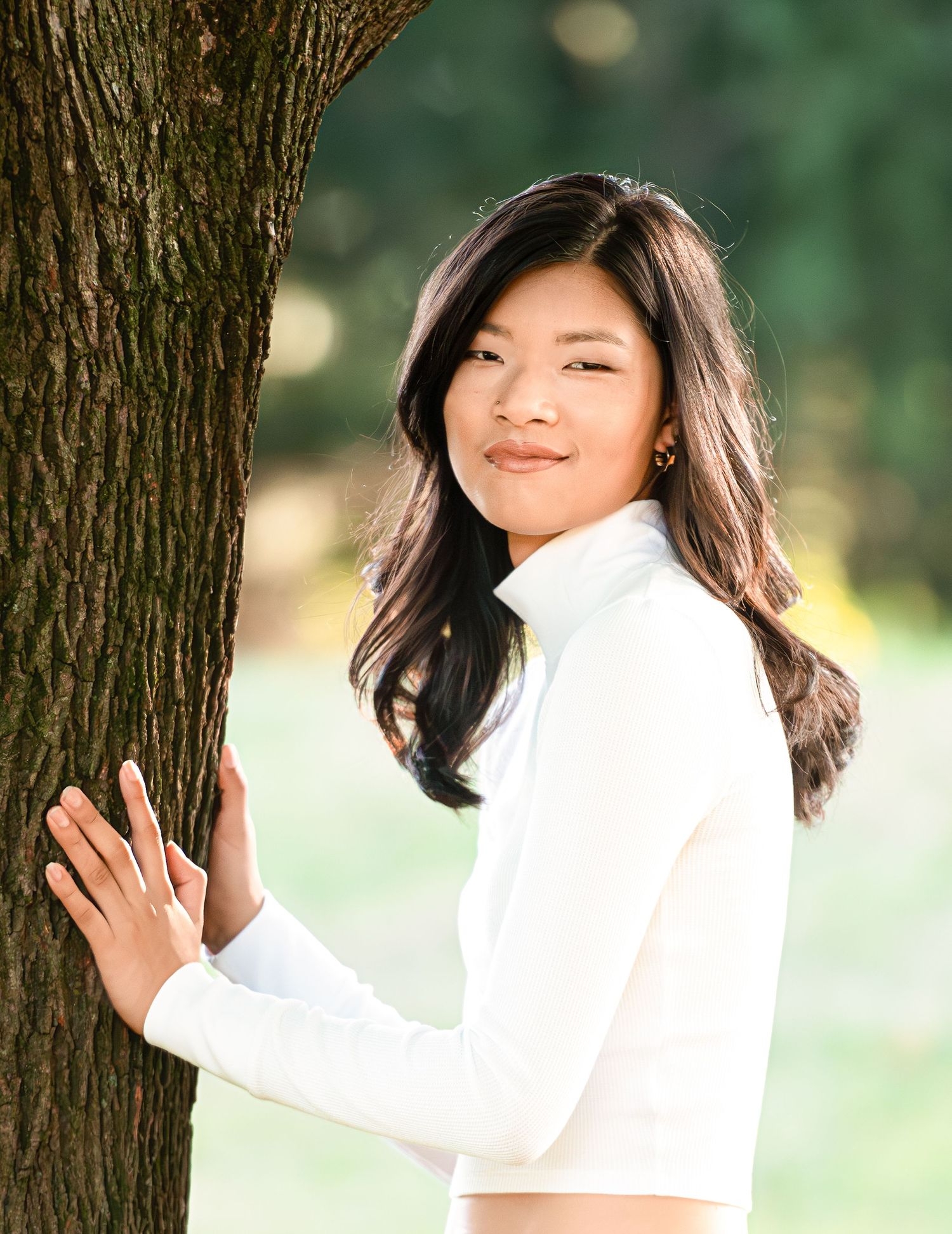 A series of playful poses next to a tree trunk in a sunny outdoor setting.