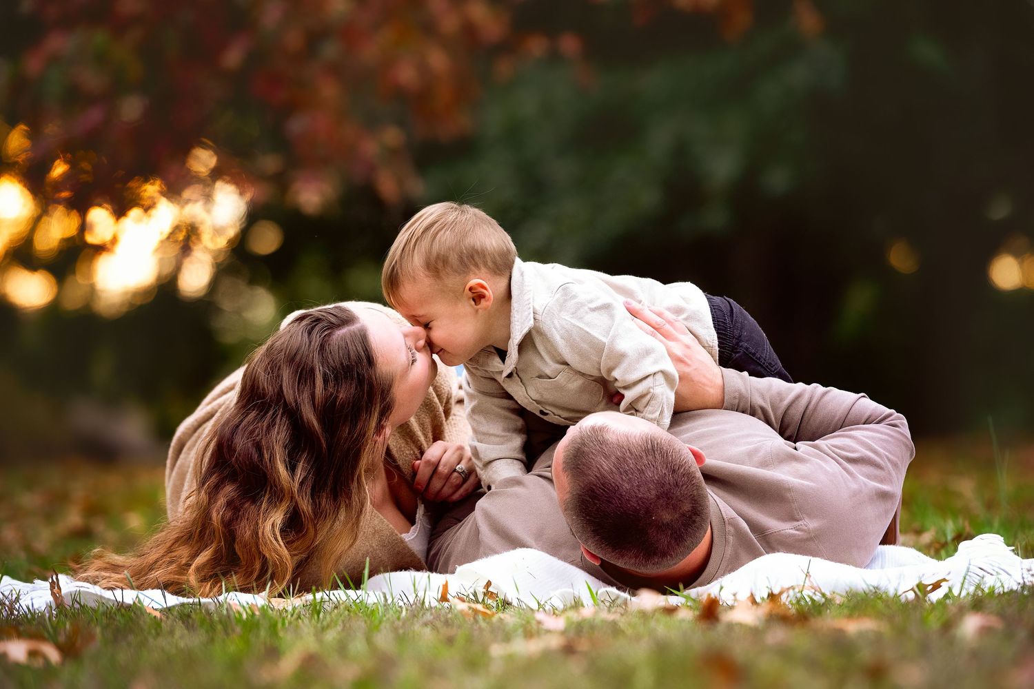 Intimate family portraits on a blanket surrounded by autumn foliage.