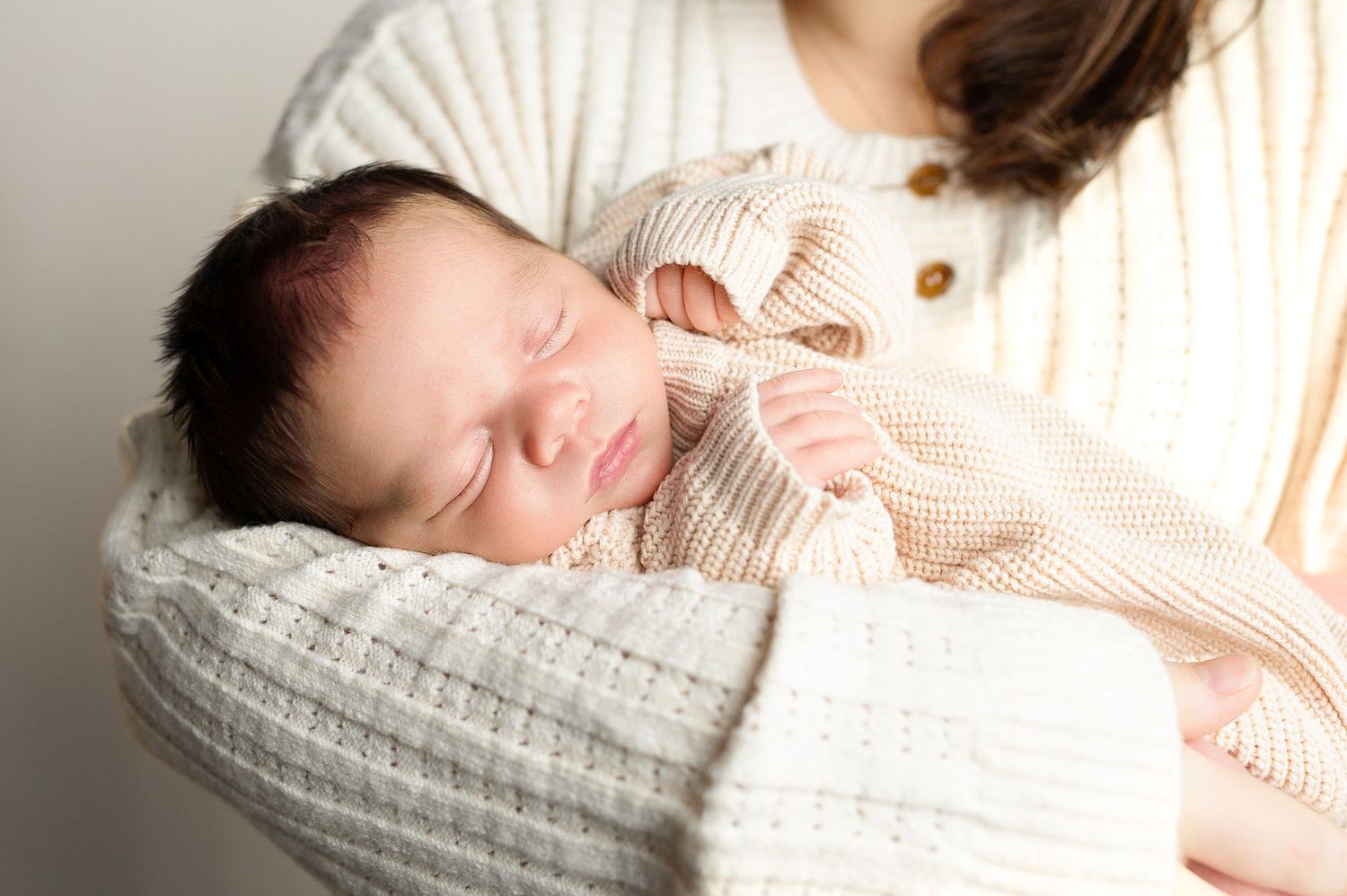 A peaceful series of newborn photography shots featuring soft white blankets and gentle natural lighting.