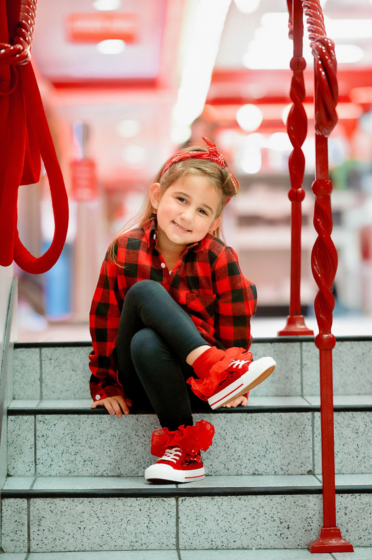 Red and white themed photoshoot location with industrial-style railings and steps.