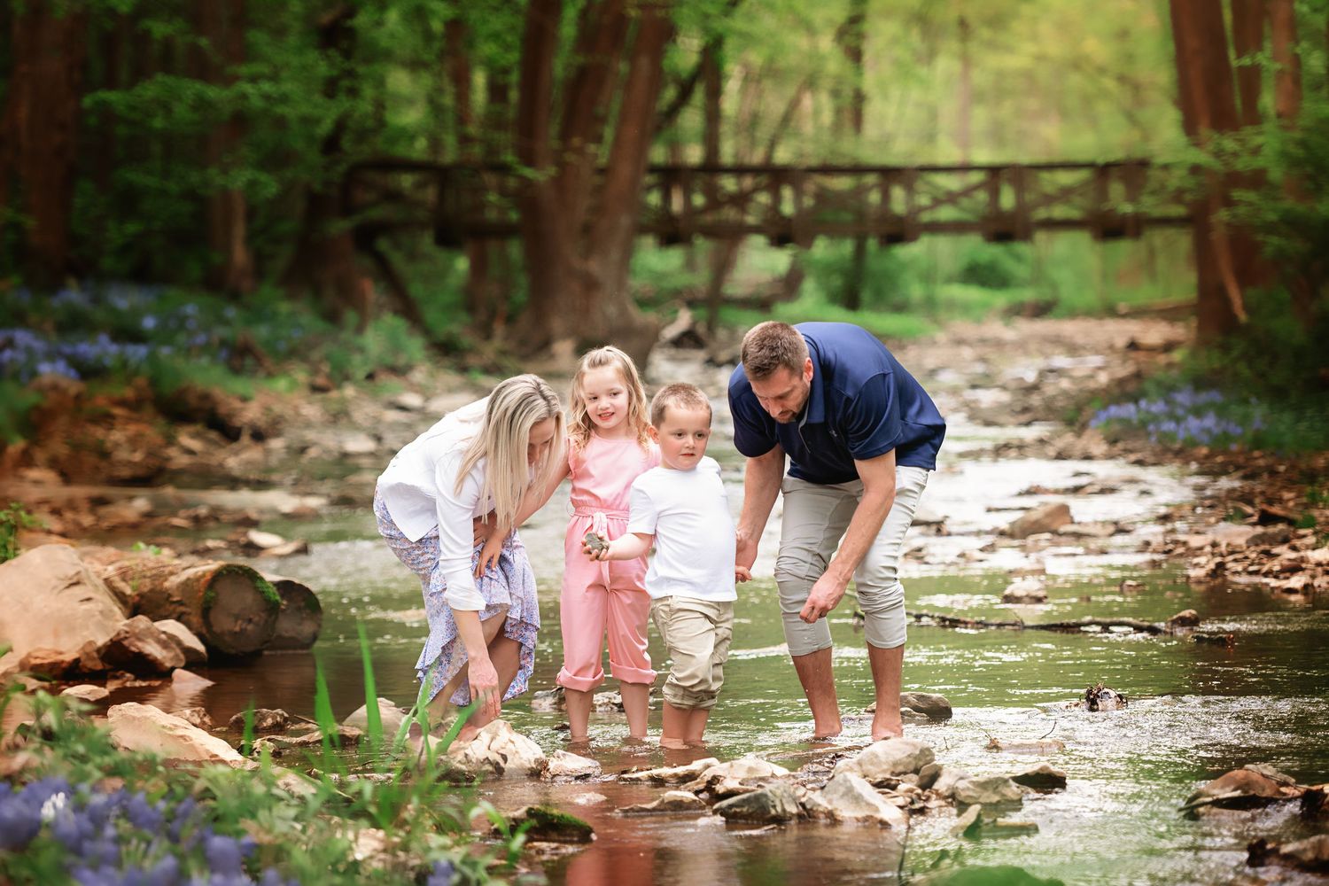 Family enjoying time together by a scenic creek with natural stone elements.