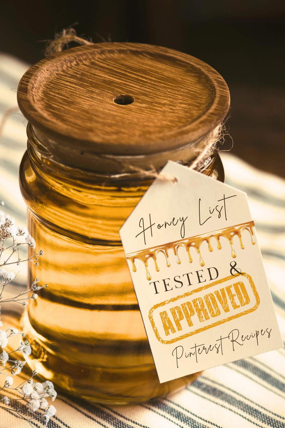 Amber glass honey jar with wooden lid and a tag reading Honey List Tested and Approved Pinterest Recipes.