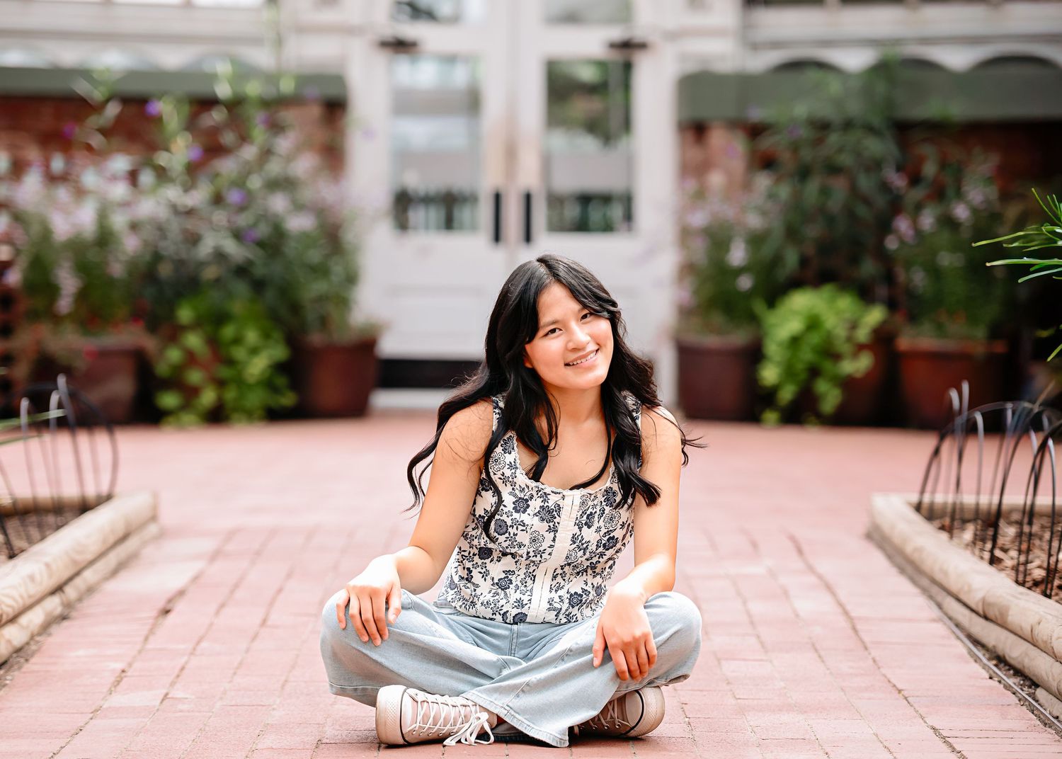 Casual portrait series on pink brick pavement wearing comfortable denim and white lace top.