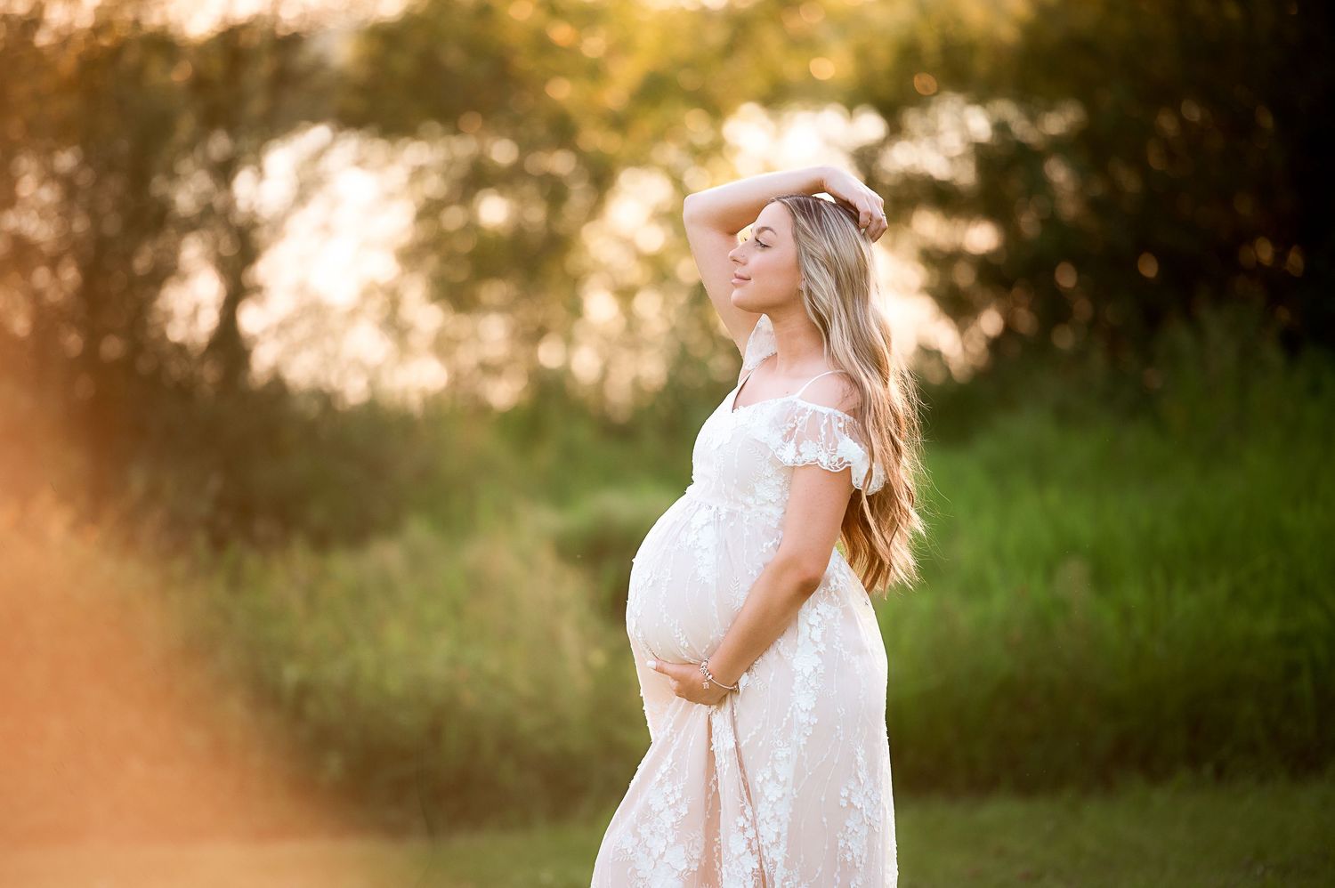 Golden hour maternity portraits in natural outdoor setting.