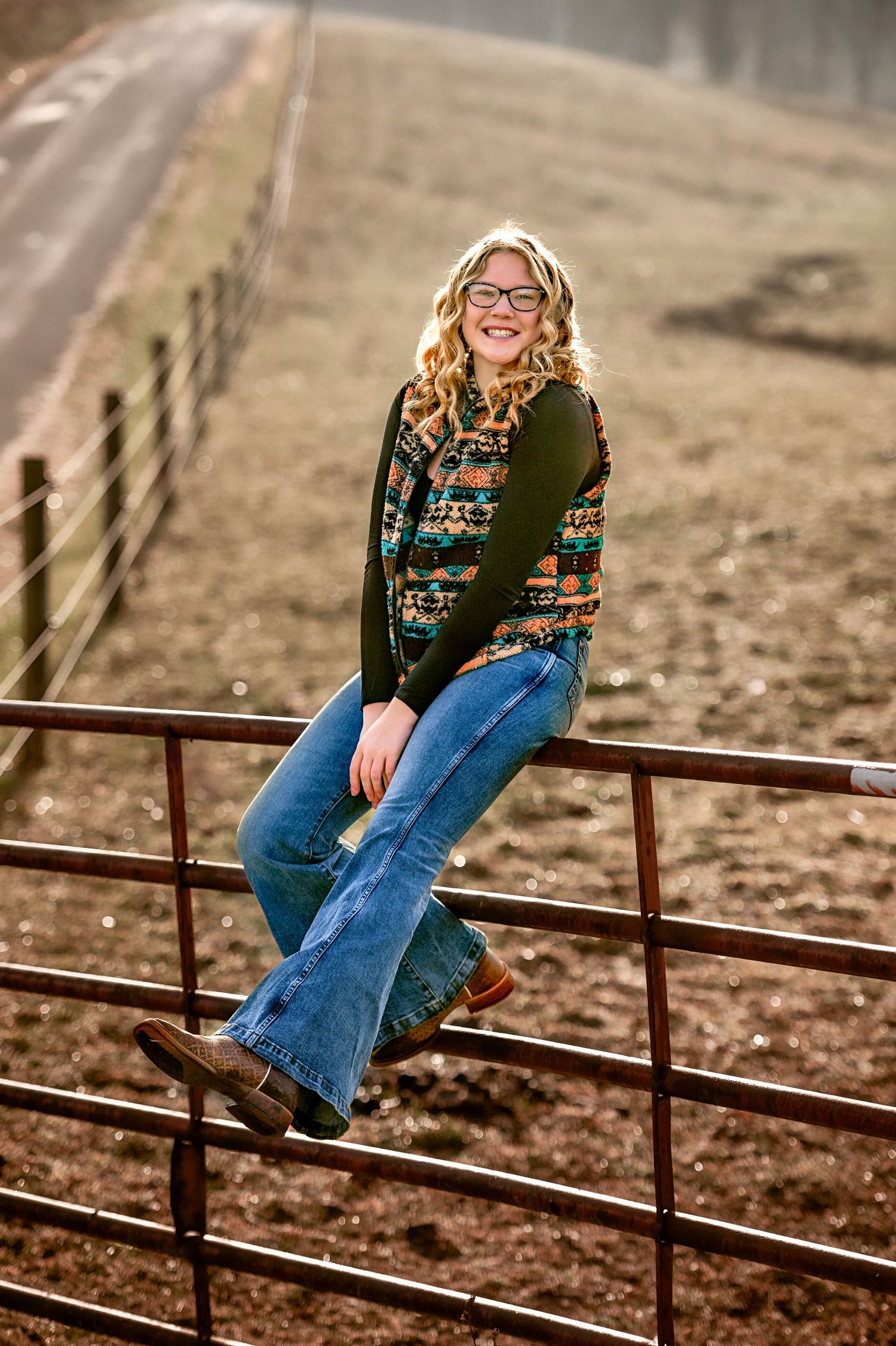 Country lifestyle portrait on curved metal fence rails with fallen autumn leaves.