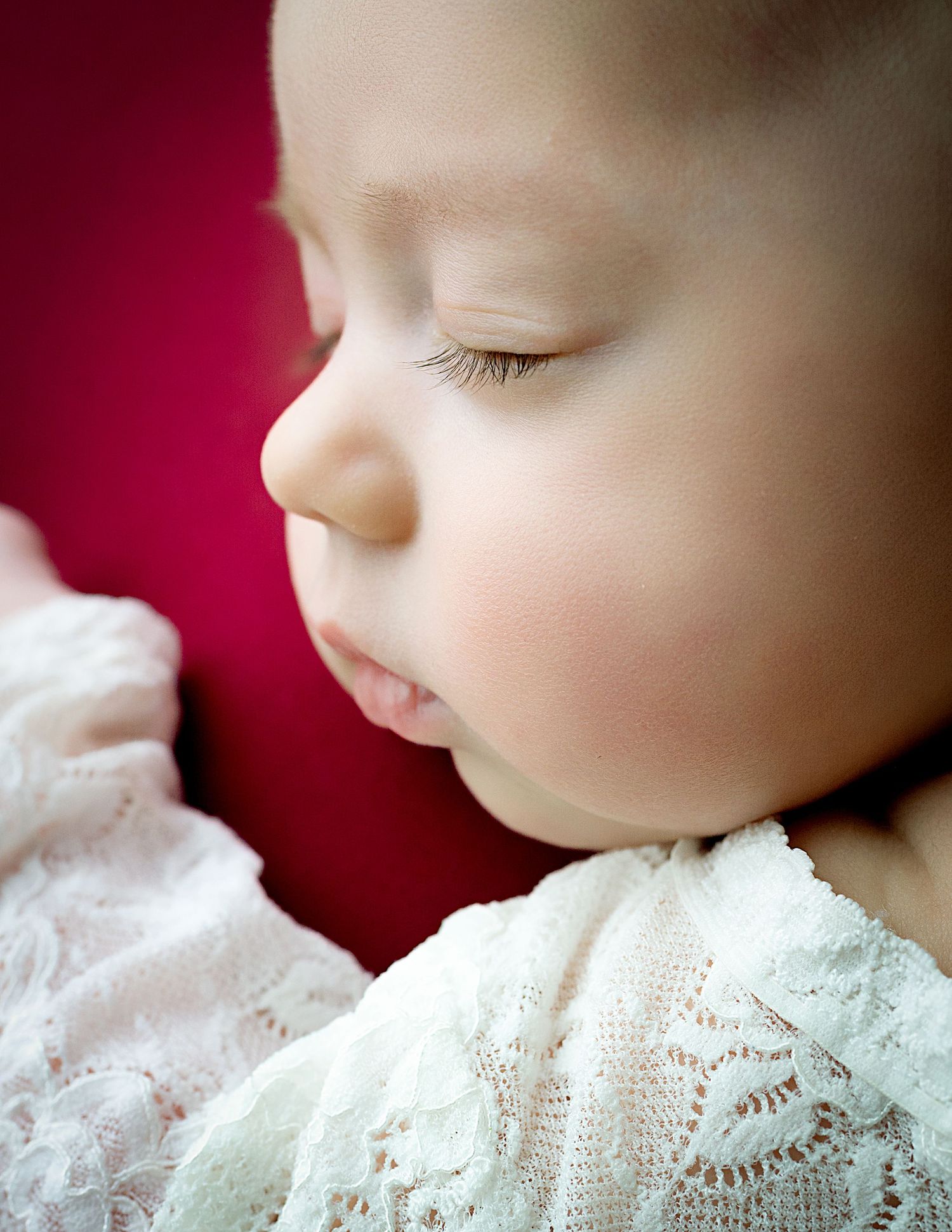 Close-up series showing delicate lace details against burgundy background in soft focus.