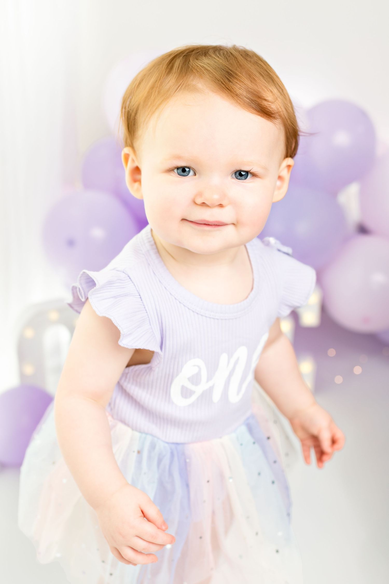 Dreamy studio setup with purple and white balloons creating a whimsical atmosphere.