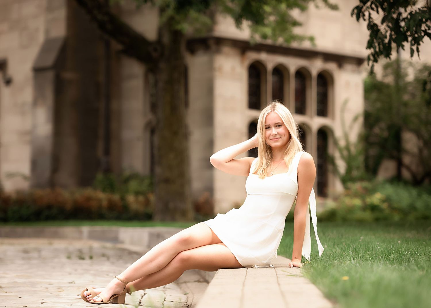 An elegant outdoor portrait on stone steps with Gothic architecture in the background.