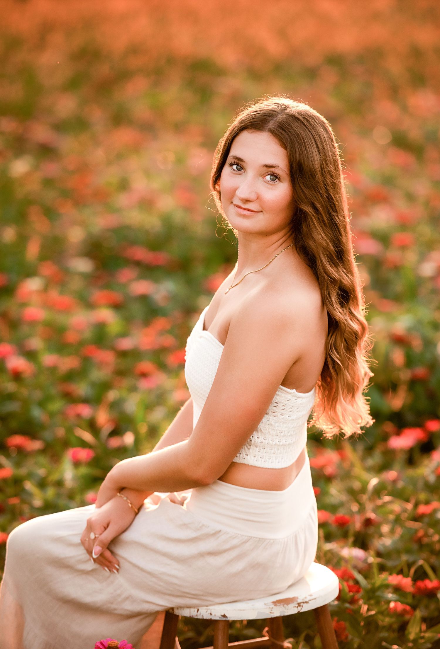 Outdoor portrait in a field of red flowers during golden hour.