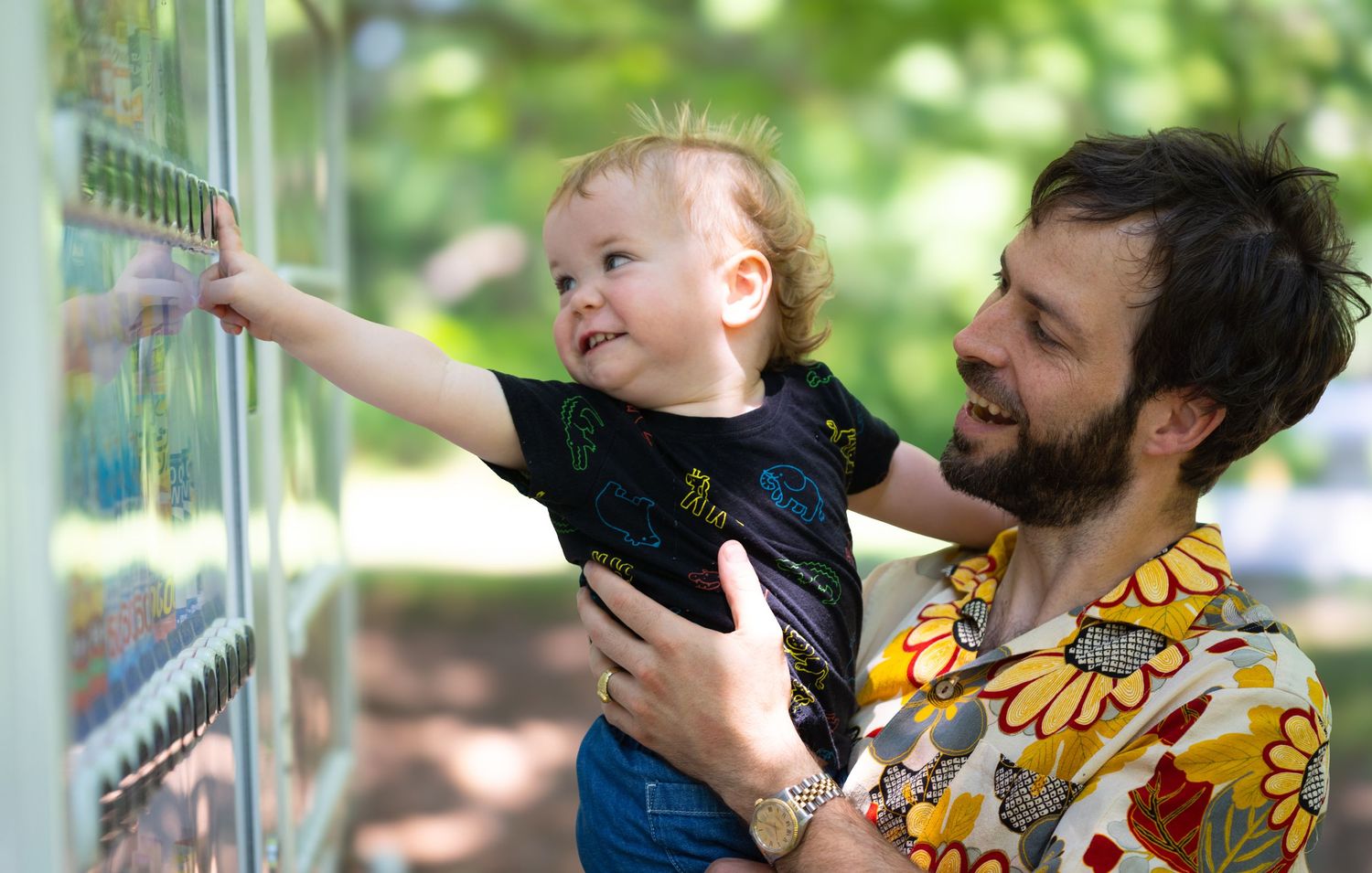 Two people share an intimate moment while standing near a metal fence outdoors.