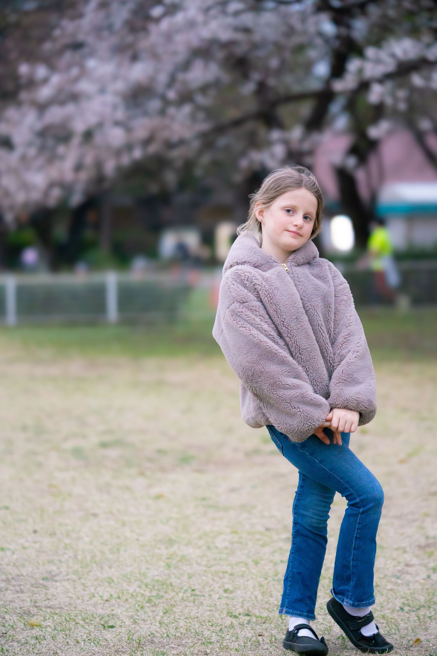 Casual pose in a cozy fleece jacket with cherry blossoms in background.