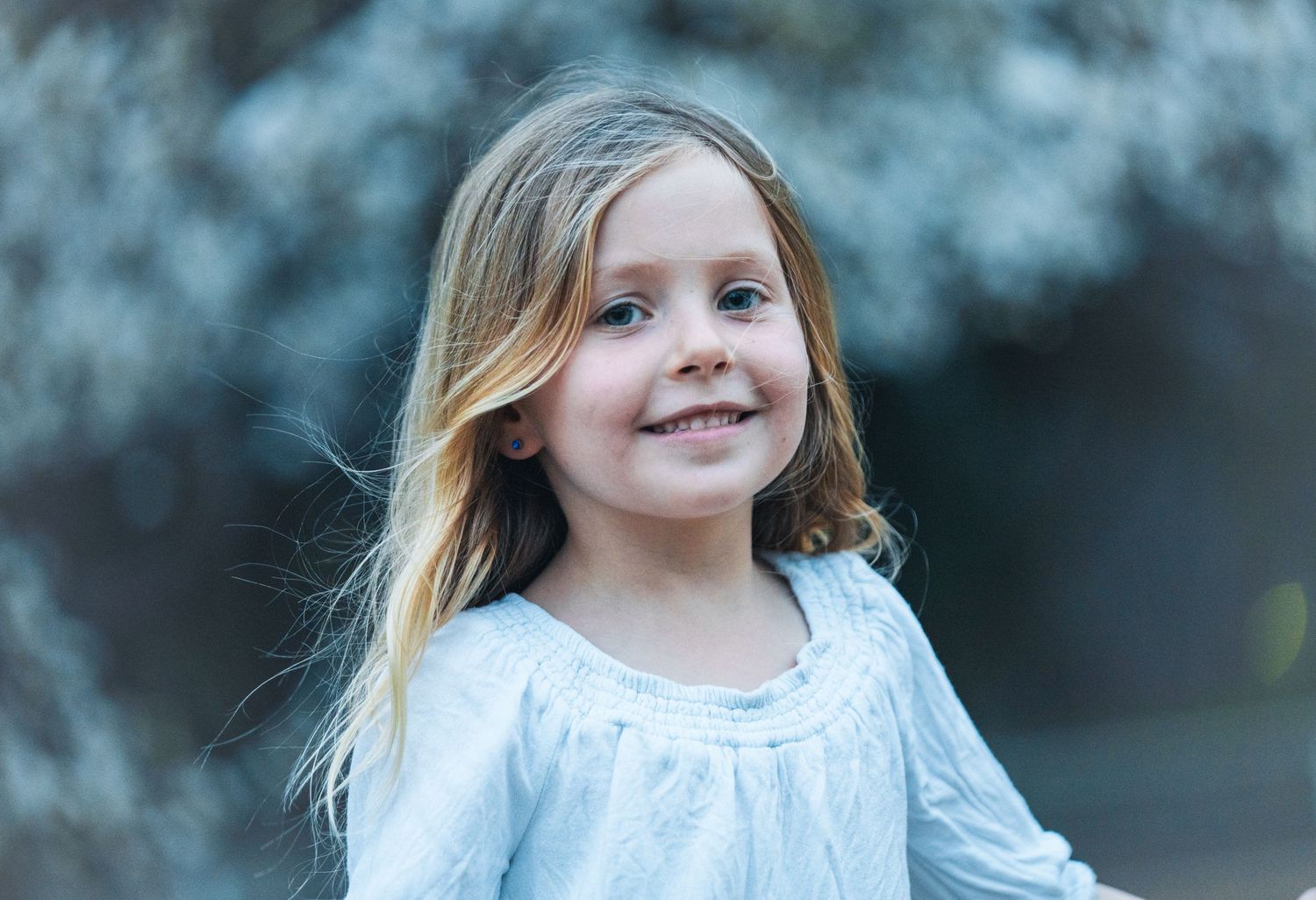 Springtime portrait with soft blue bokeh background.
