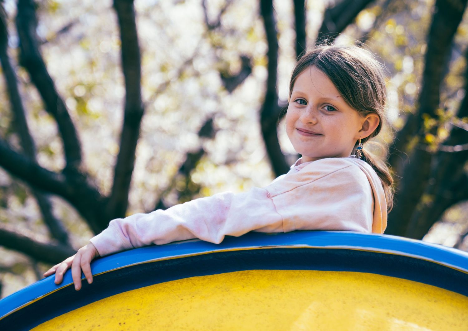A sunny day at the playground with a yellow and blue play structure.