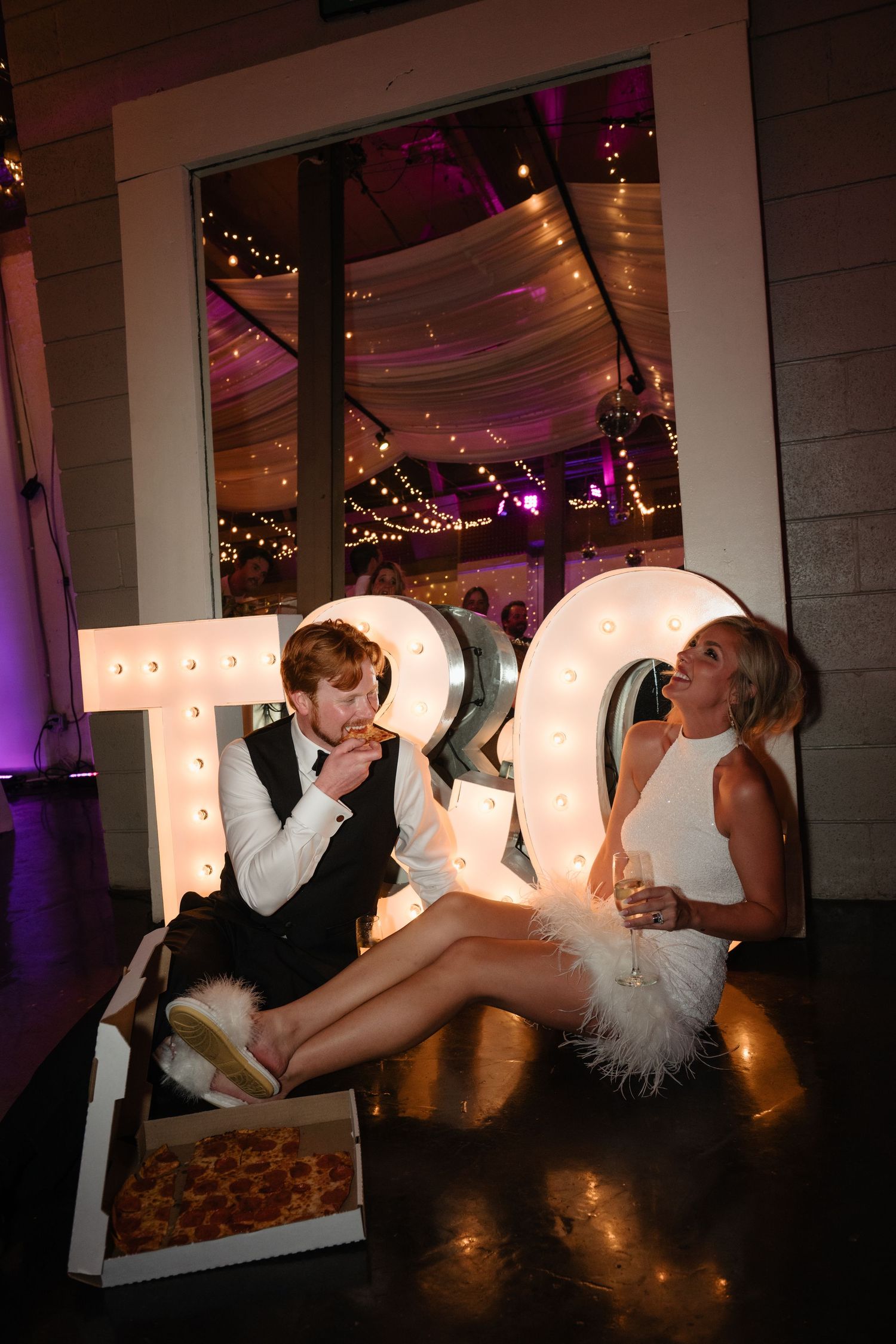 A bride and groom sitting together at a reception.