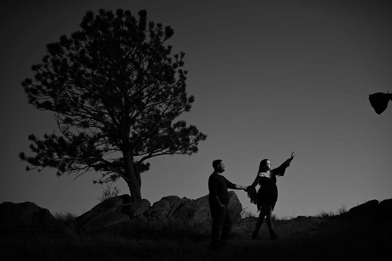 Silhouettes of two people on horseback against a sunset sky.