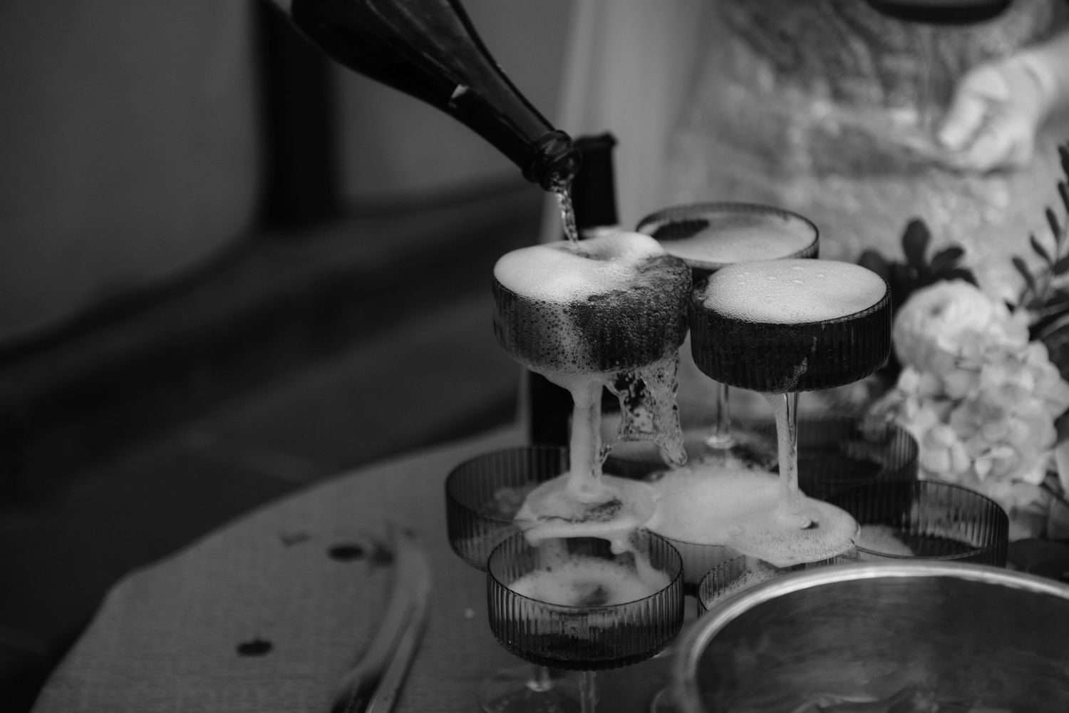 A black and white image shows various coffee and espresso drinks being prepared on a counter.