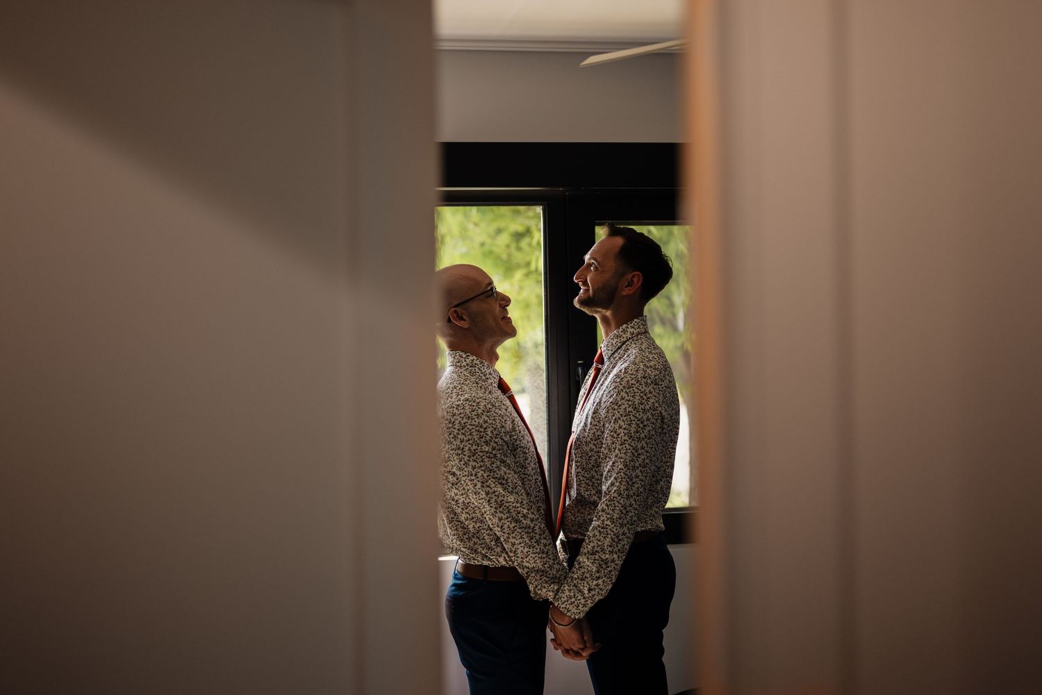 Two people standing and facing each other in a doorway.
