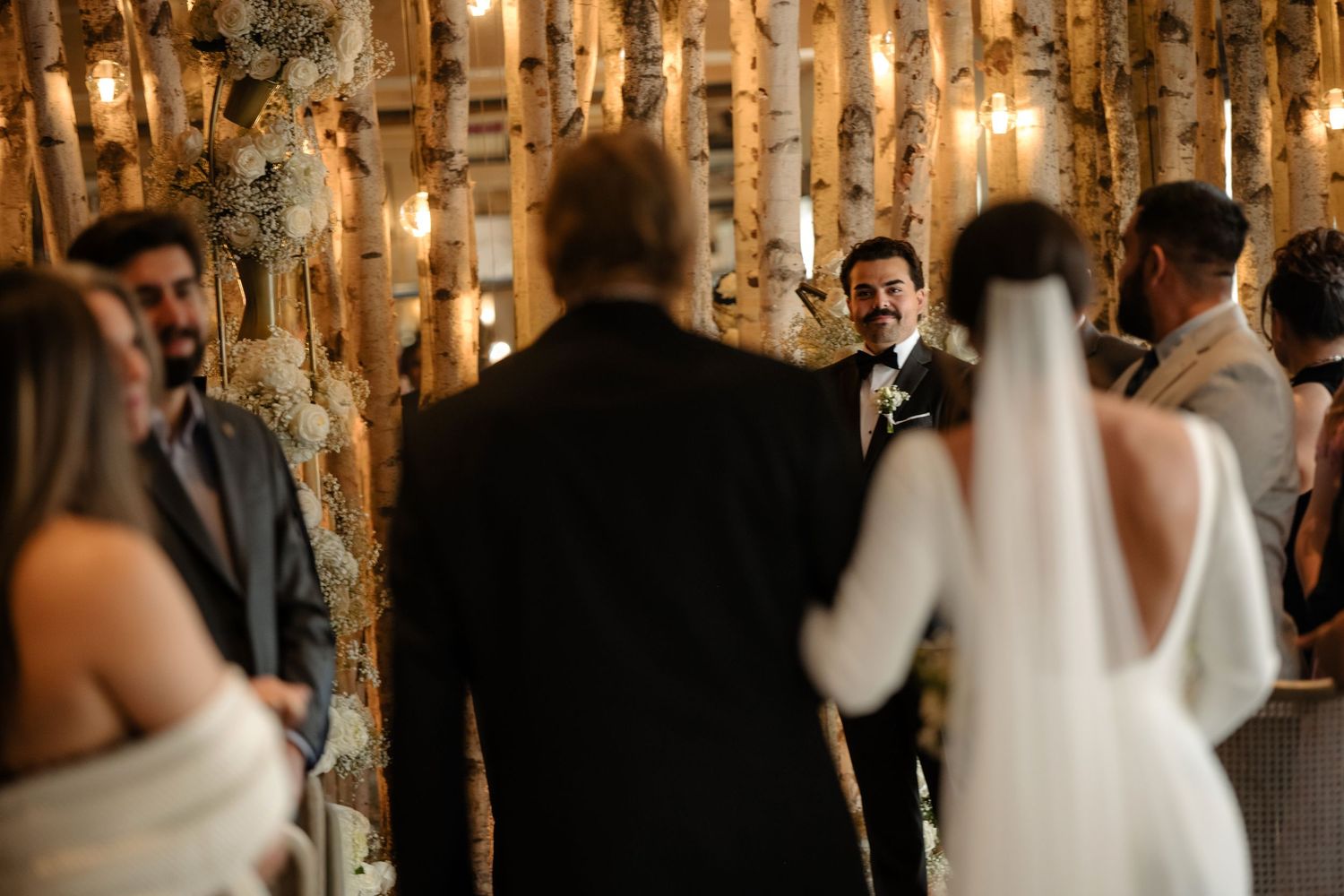 A wedding ceremony taking place in a rustic indoor setting with wooden decor.