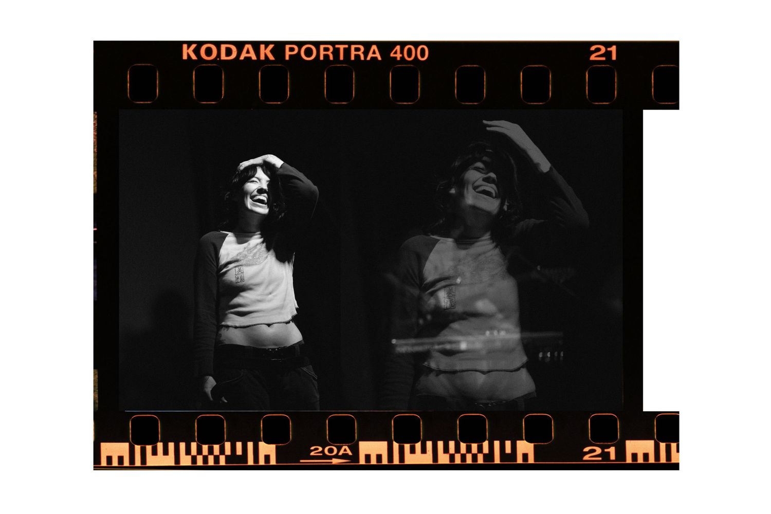 Black and white film strip photo on Kodak Portra 400 showing two people posing dramatically in low light.